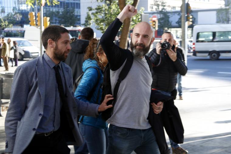 El regidor de la CUP Josep Garganté aixeca el puny davant de la Guàrdia Urbana mentre marxa de la Ciutat de la Justícia després de quedar absolt