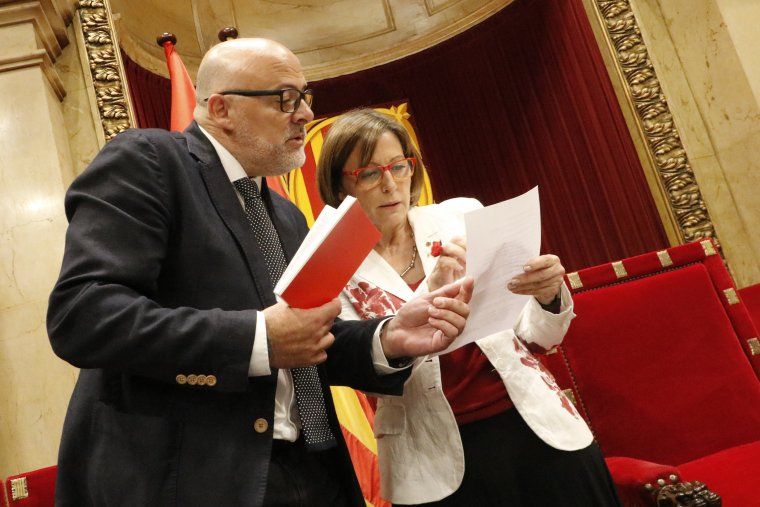 La presidenta del Parlamento, Carme Forcadell, y el vicepresidente, Lluís Corominas, mirando el reglamento del Parlamento