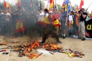 Un manifestant d'ultradreta saludant mentre estan cremant estelades