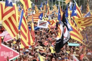 Un cartell de "llibertat presos polítics" enmig de les estelades onejant a la manifestació de la Diada
