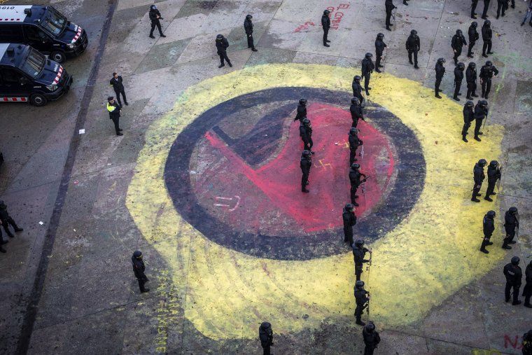 Imatge aèria de la manifestació a Girona en protesta per la concentració espanyolista, els Mossos sobre el símbol antifeixista