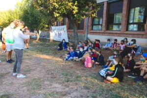 La mestra explicant als nens com posar-se la mascareta al pati de l'escola Els Pins de Cabrianes, el 14 de setembre del 2020 / ACN