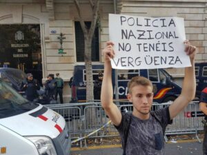 Un noi sost&eacute; un cartell contra la policia espanyola davant de la delegaci&oacute; del govern espanyol a Catalunya