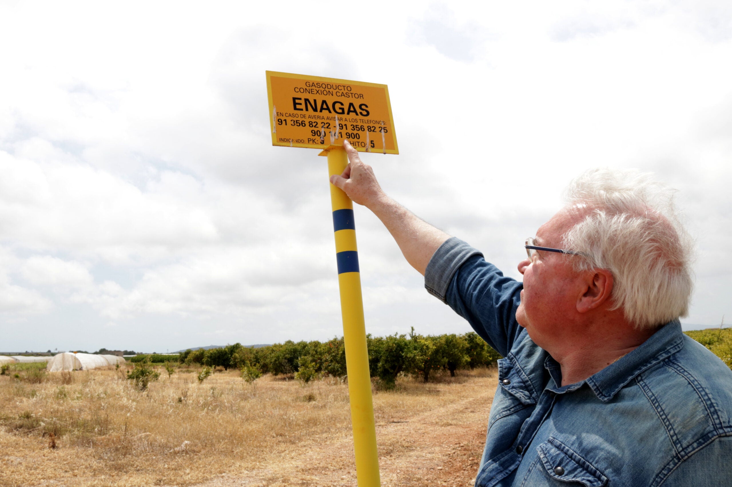 El portaveu de la Plataforma del Sénia, Evelio Monfort, mostrant la placa de la fita del gasoducte de connexió de projecte Castor, a Vinaròs. / ACN