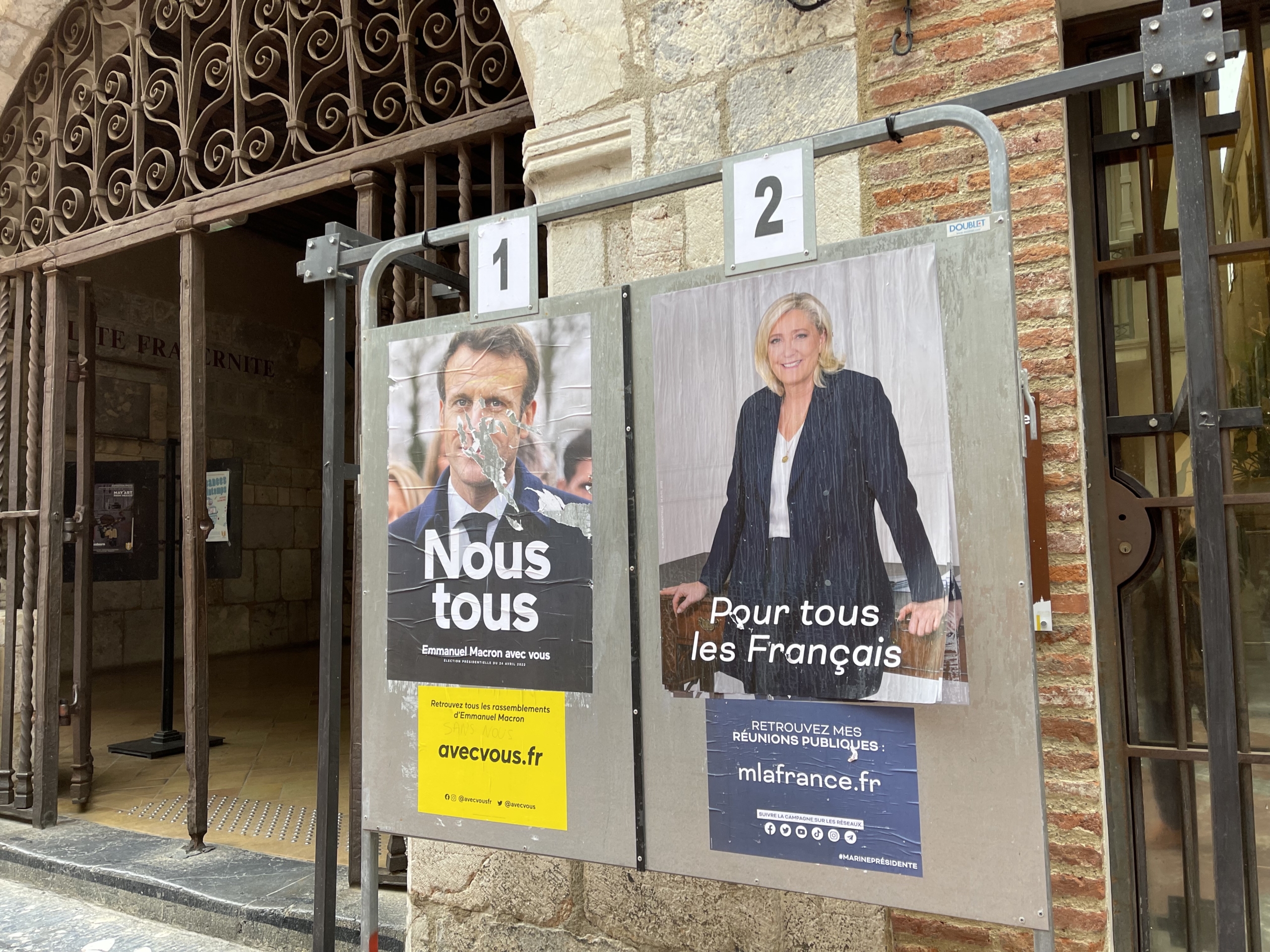 Panell electoral de Macron (esguerrat) amb el de Le Pen a l'entrada de l'Ajuntament de Perpinyà/Quico Sallés