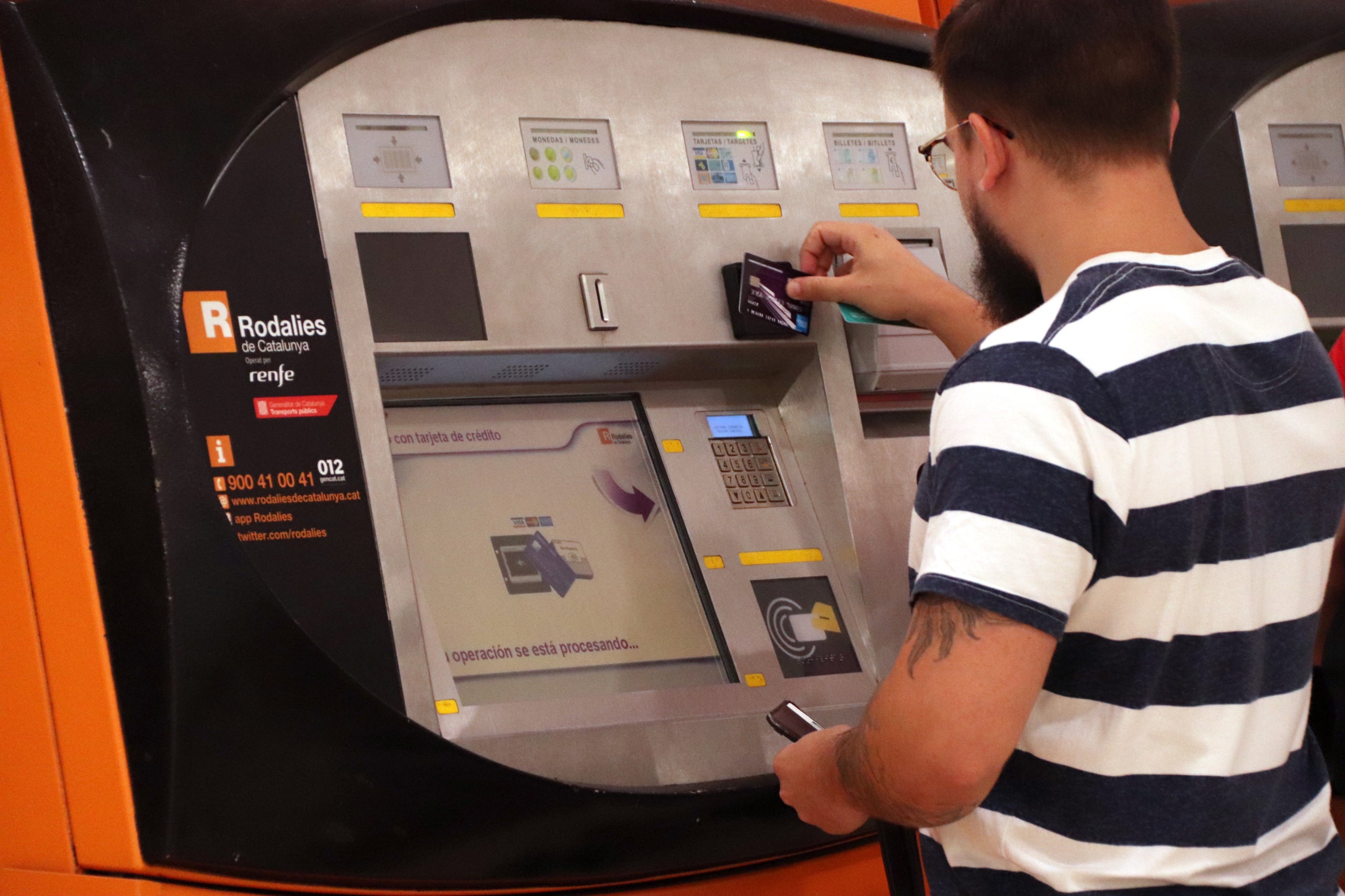 Un noi utilitzant una màquina d'autovenda de Rodalies el primer dia en vigor dels abonaments gratuïts | ACN