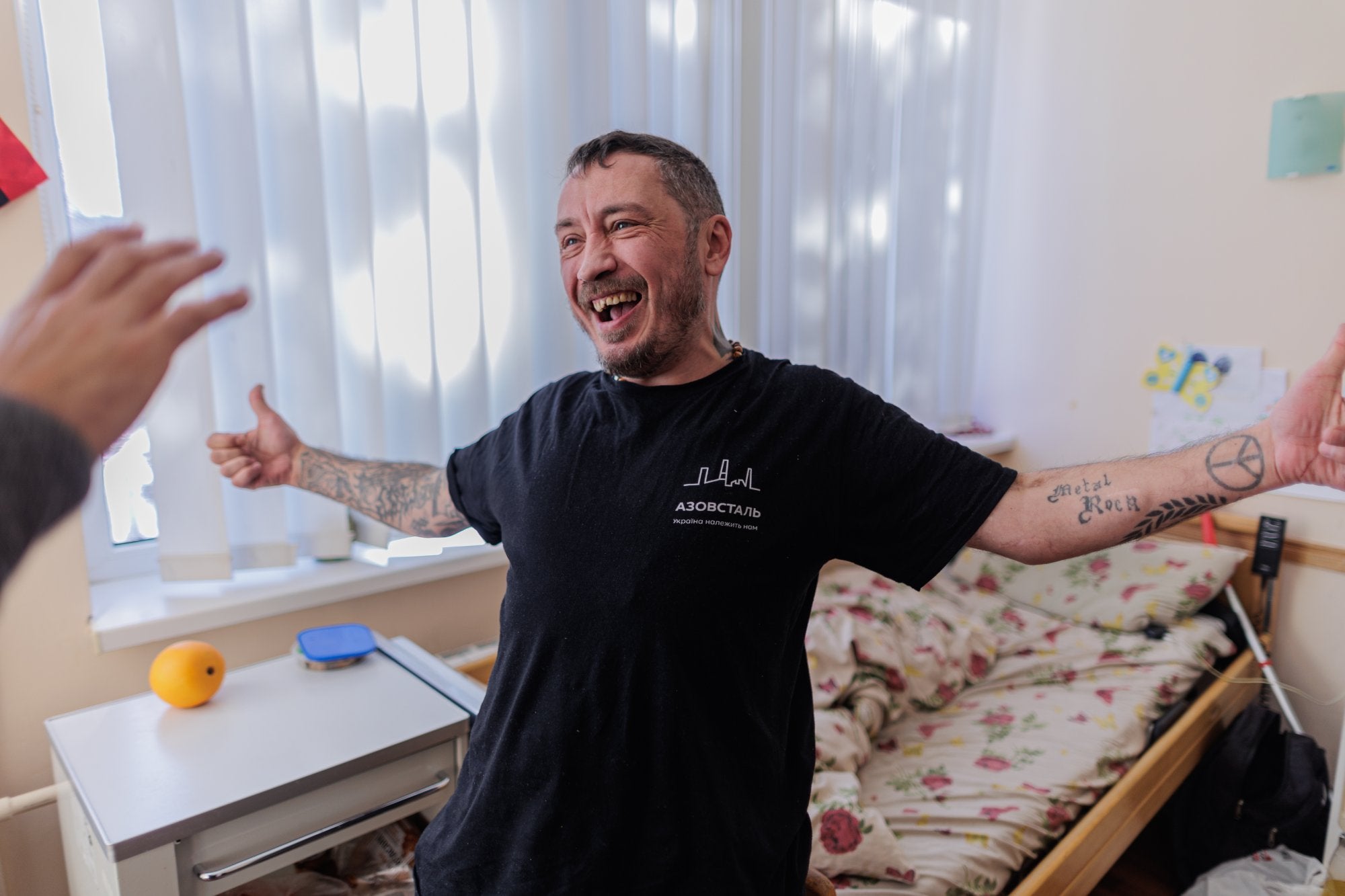 Ell es en Vitaly, un combatent del batalló Azov. El batalló, que va estar especialment actiu a Mariupol el 2014 i el 2015, és una força de combat eficaç i molt compromesa en el conflicte actual que té un historial d'inclinacions neonazi, que no va desaparèixer del tot una vegada que es va integrar a l'Exèrcit d'Ucraïna. Les branques militar i política del moviment es van distingir el 2016, quan es va fundar el partit d'ultradreta Cos Nacional i el Batalló Azov s'havia integrat a la Guàrdia Nacional d'Ucraïna.