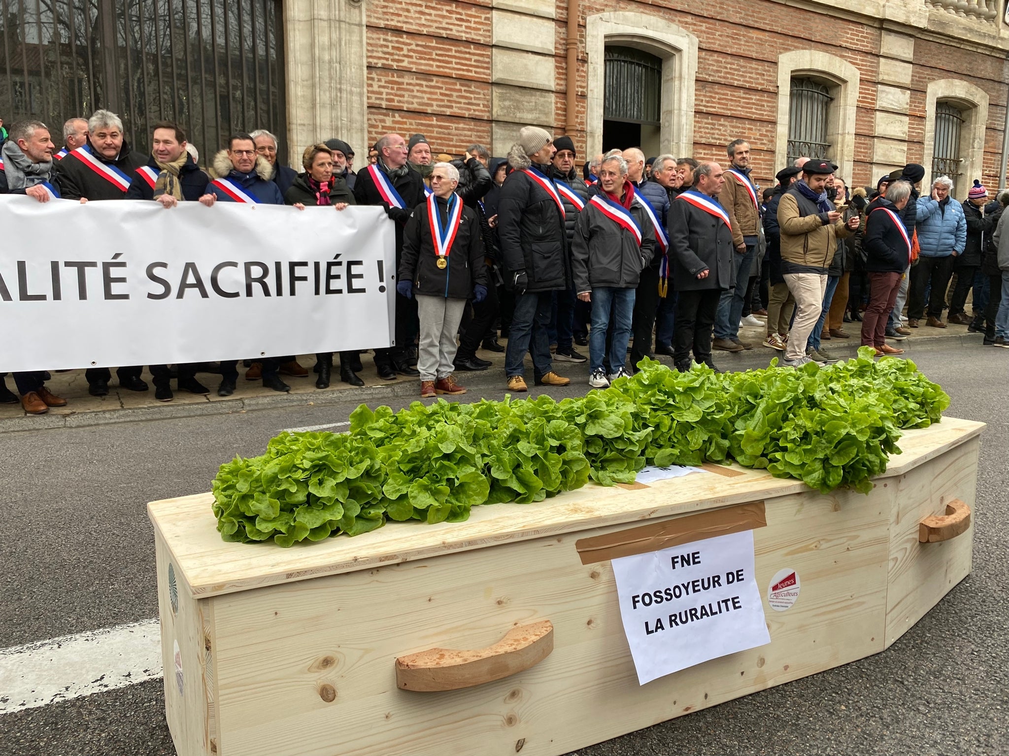 Davant de la prefectura de Perpinyà, els agricultors dipositen un taüt amb l’epígraf: “FNE enterramorts de la ruralitat”. Foto Lluís Dagues.