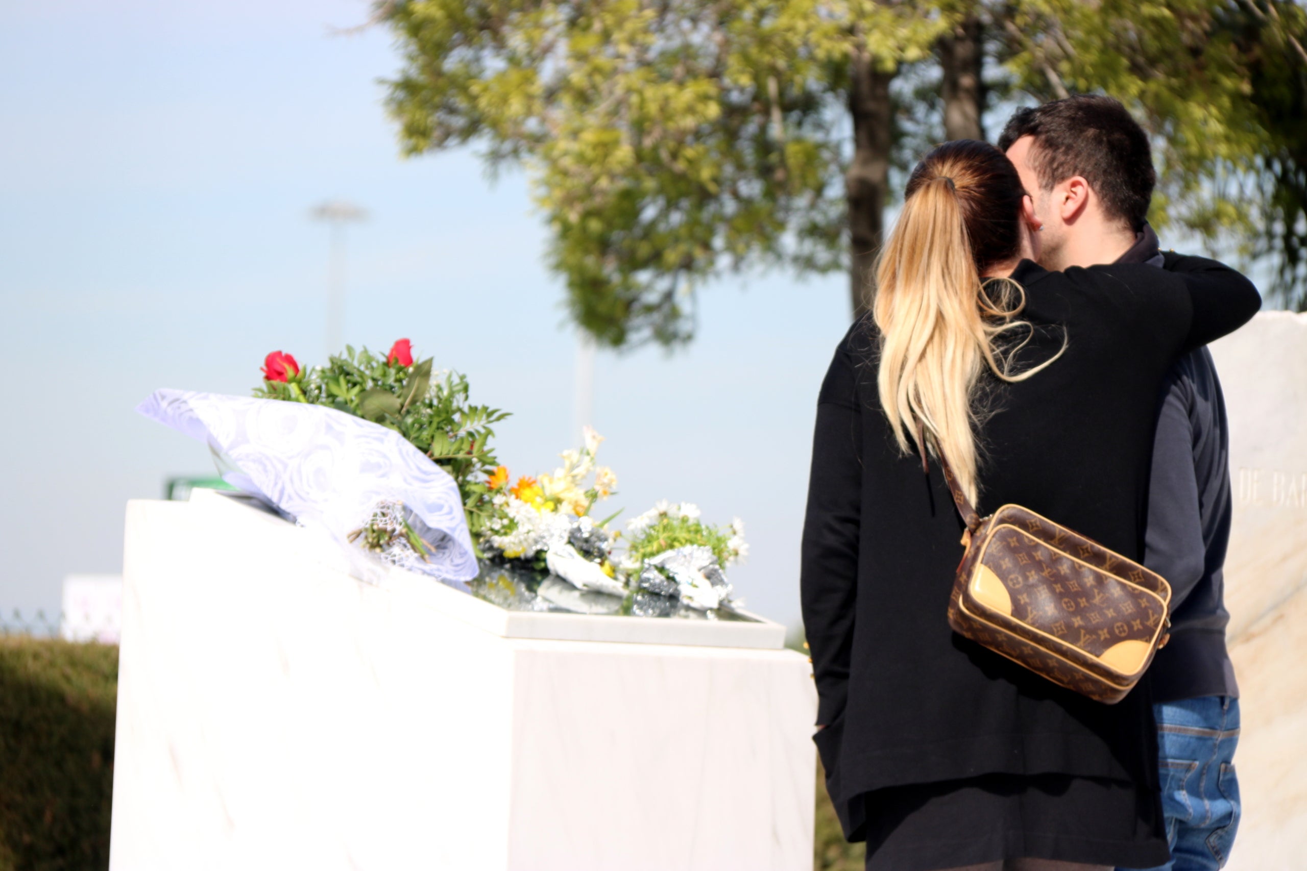 Una pareja recordando sus familiares al monolito en recuerdo de las víctimas del accidente de Germanwings que hay a la T2 del Aeropuerto del Prat el 23 de marzo de 2018 | ACN (Norma Vidal)