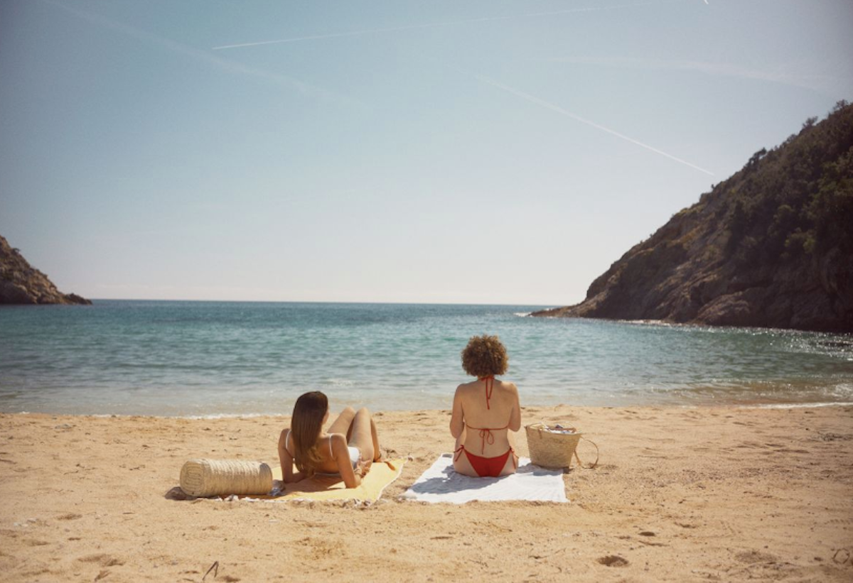 Dues persones prenen el sol a la platja