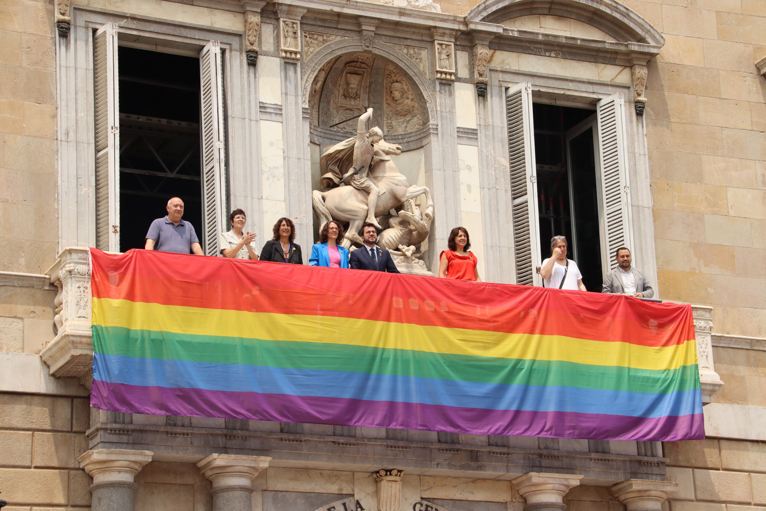 El president del Govern, Pere Aragonès, i la consellera d'Igualtat i Feminismes, Tània Verge, al balcó del Palau de la Generalitat amb la bandera LGTBI+ desplegada / ACN