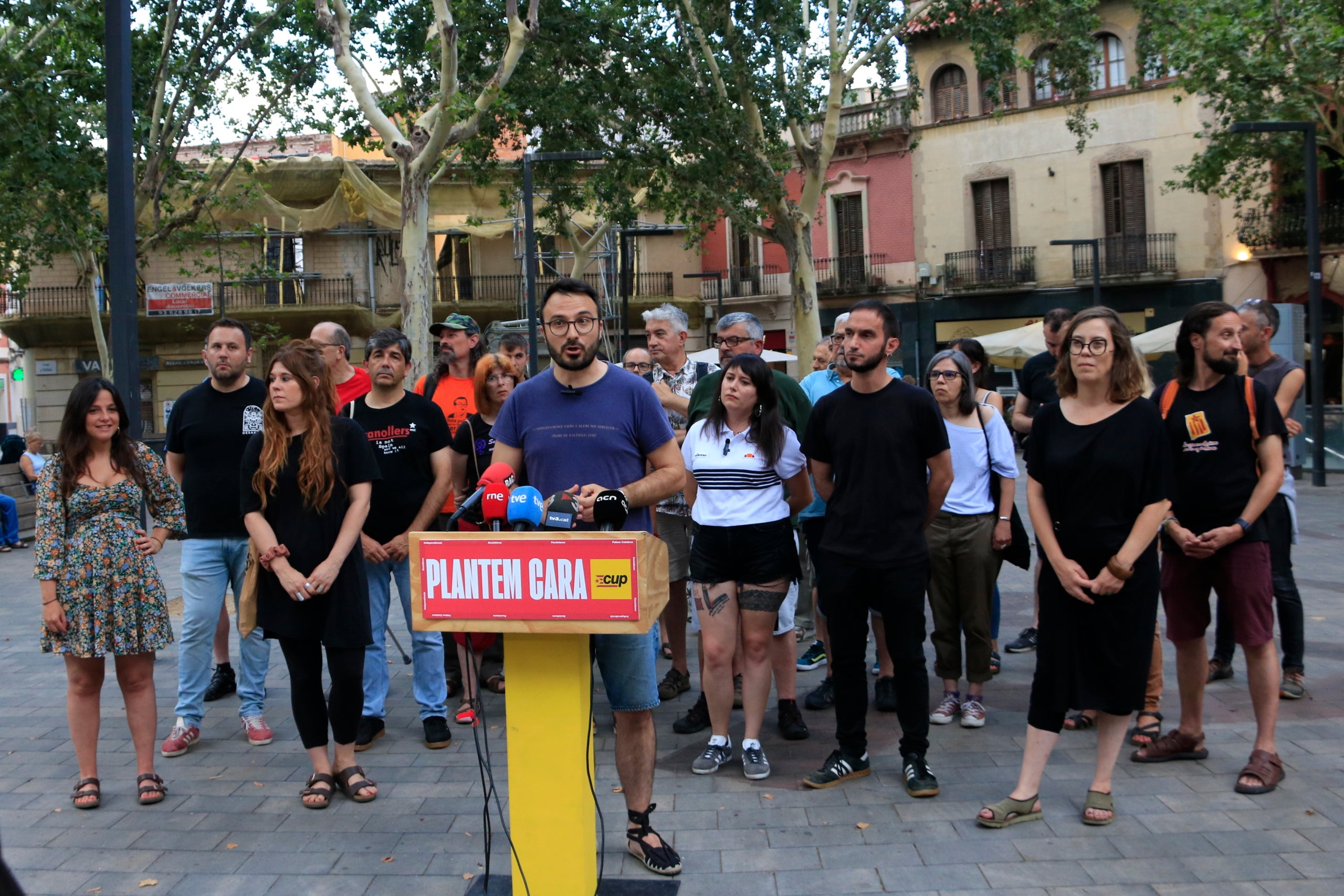 El candidat de la CUP per Barcelona, Albert Botran, atén els mitjans de comunicació a l'inici de la campanya del 23-J, acompanyat d'altres membres de la formació a la plaça d'Eivissa, al barri d'Horta de la capital catalana / ACN