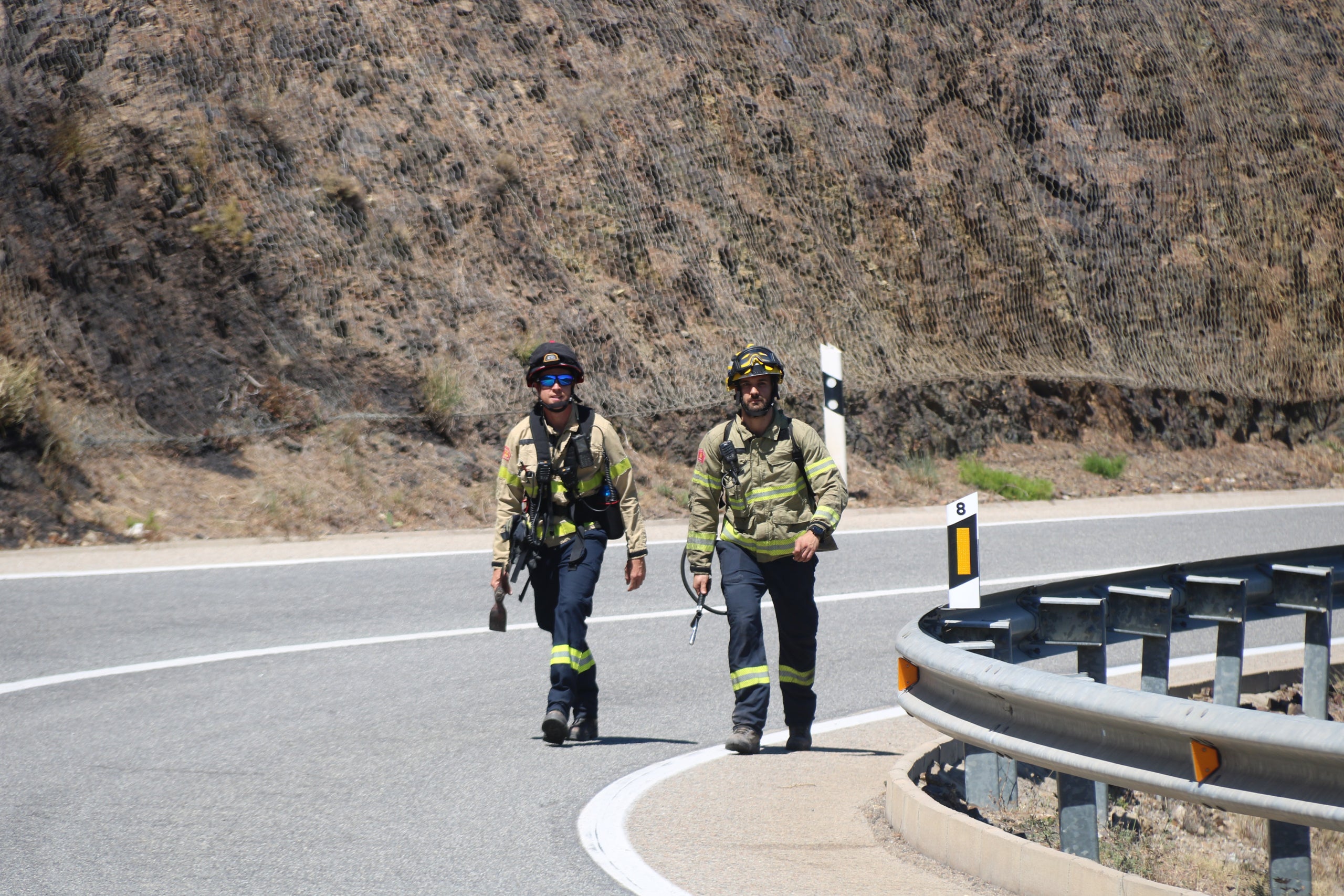 Dos bombers caminen per la carretera en una imatge d'arxiu / ACN