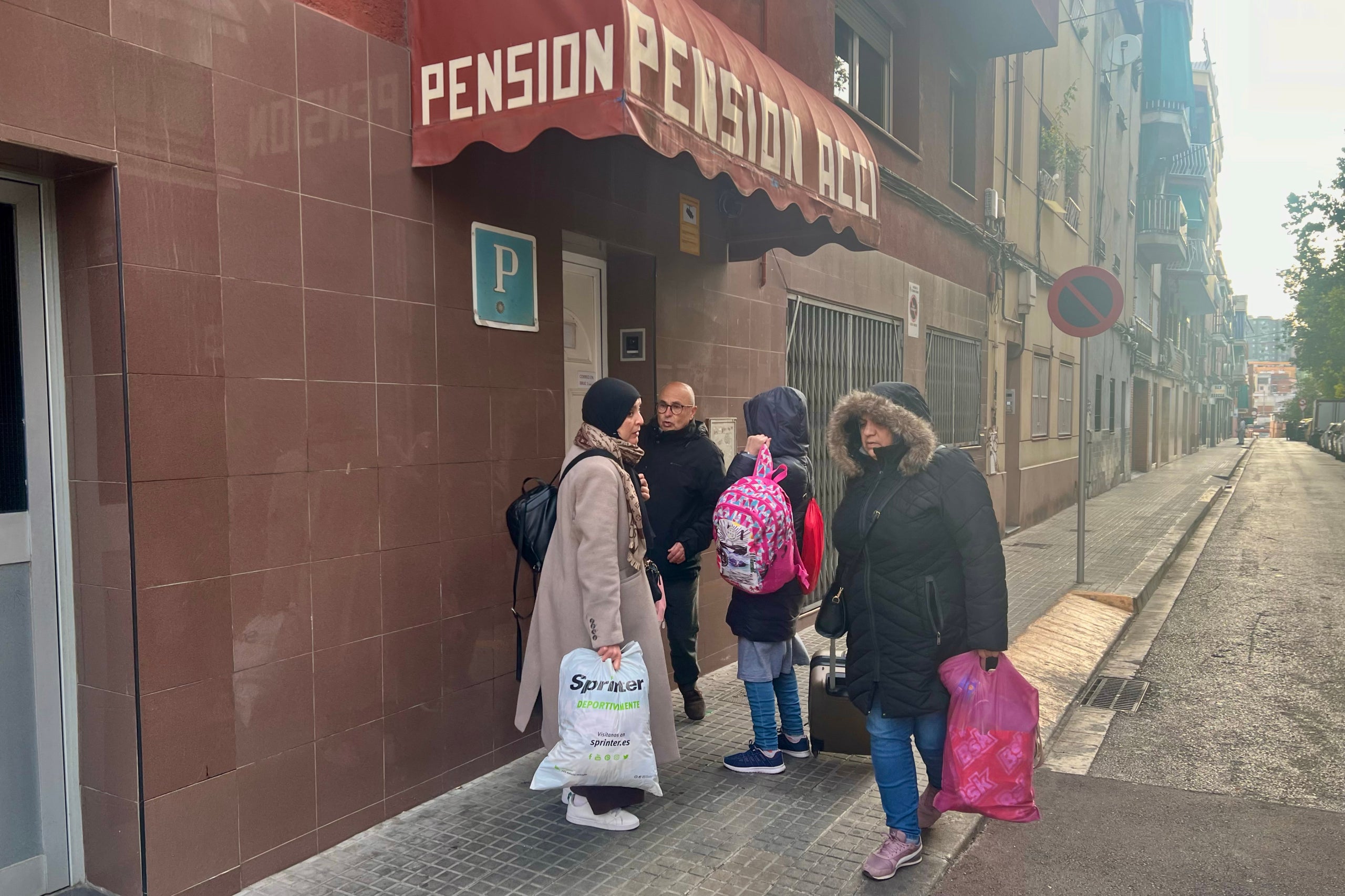 Imatge de les famílies desnonades a Badalona sortint de la pensió on s'allotjaven / ACN