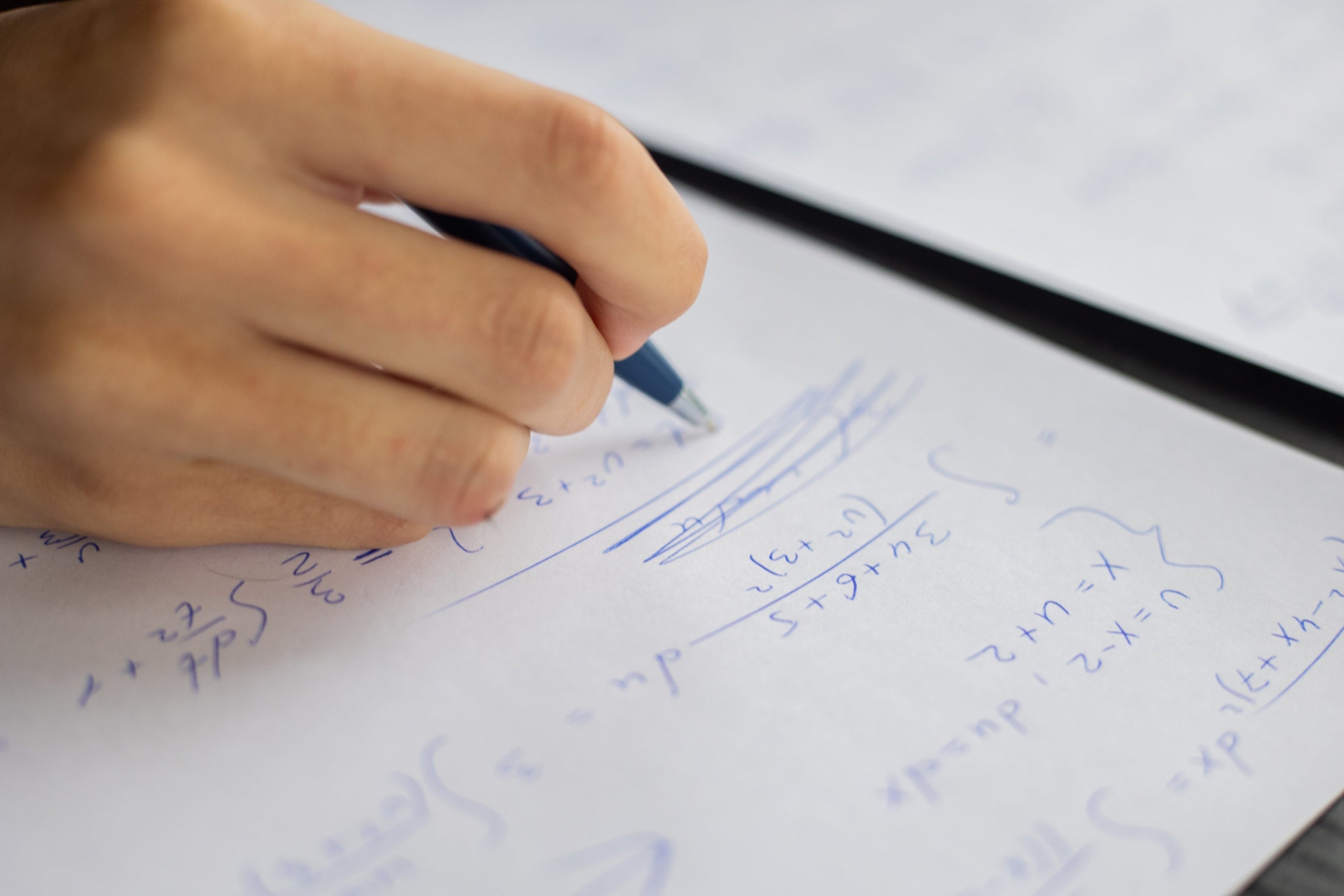 Imatge d'un alumne intentant resoldre una operació matemàtica / Pexels