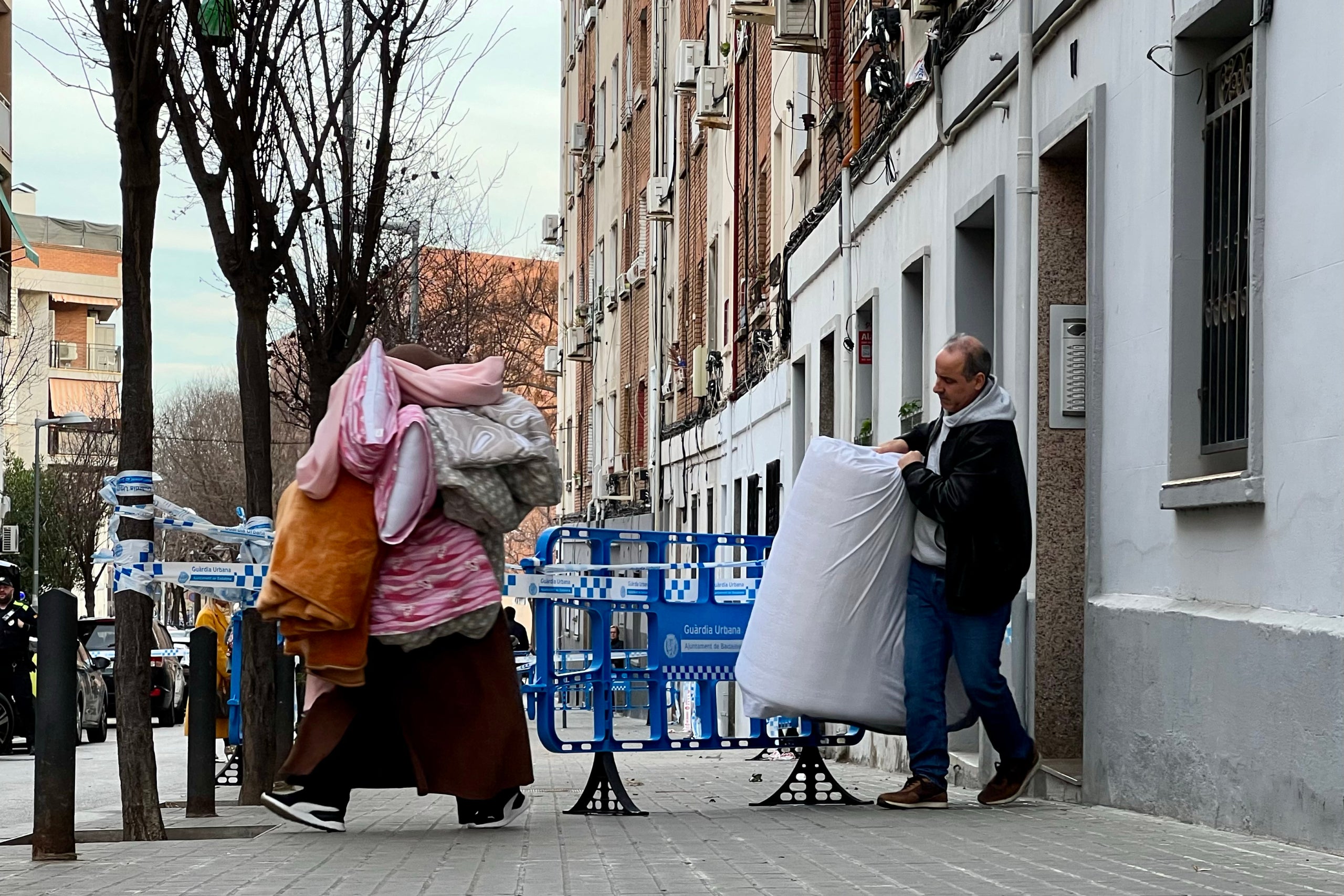 Dos veïns treuen pertinences d'un bloc desallotjat al carrer Canigó de Badalona / Jordi Pujolar (ACN)