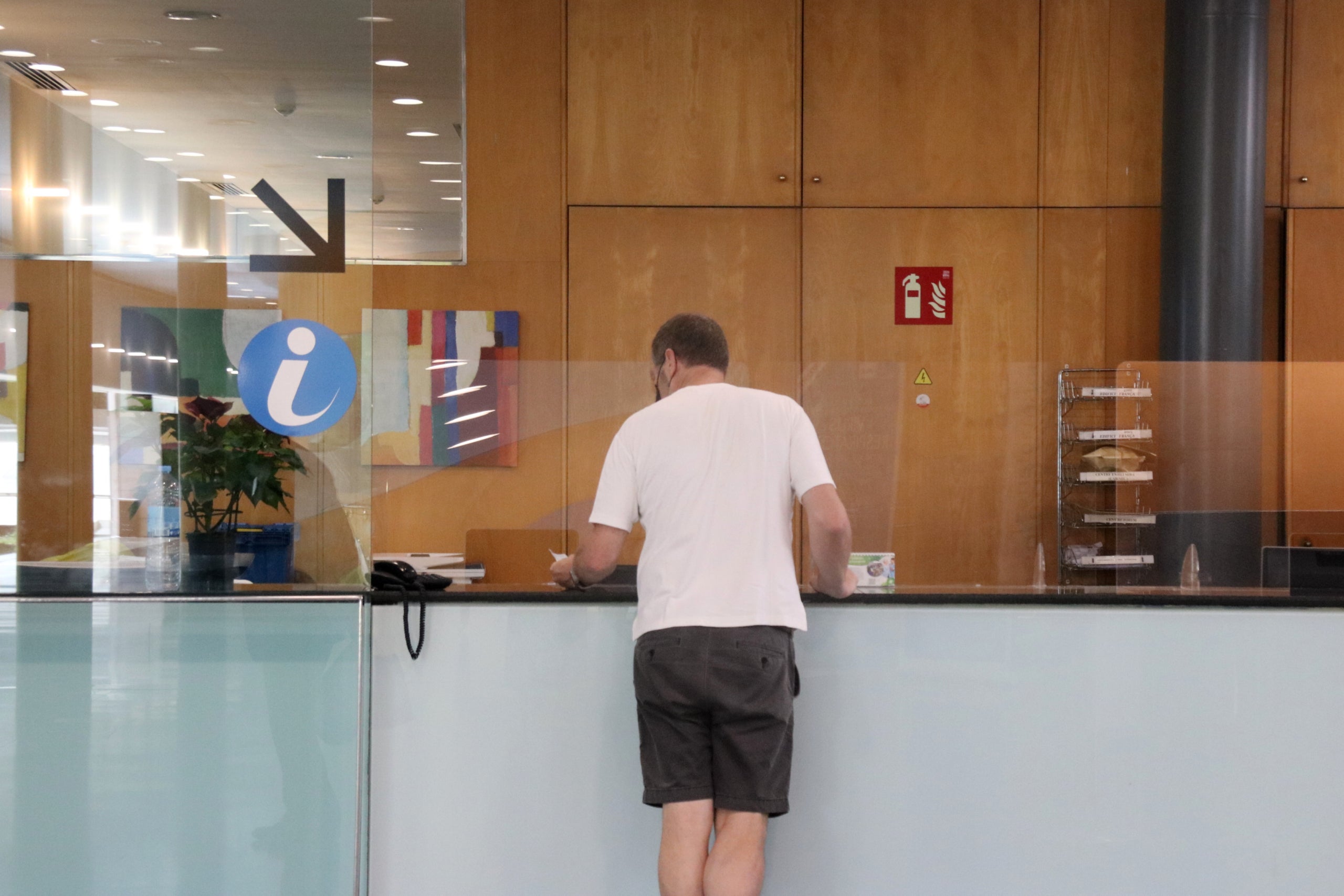Un home pregunta al punt d'informació, al vestíbul de l'Hospital del Mar / Martí Rodríguez (ACN)  