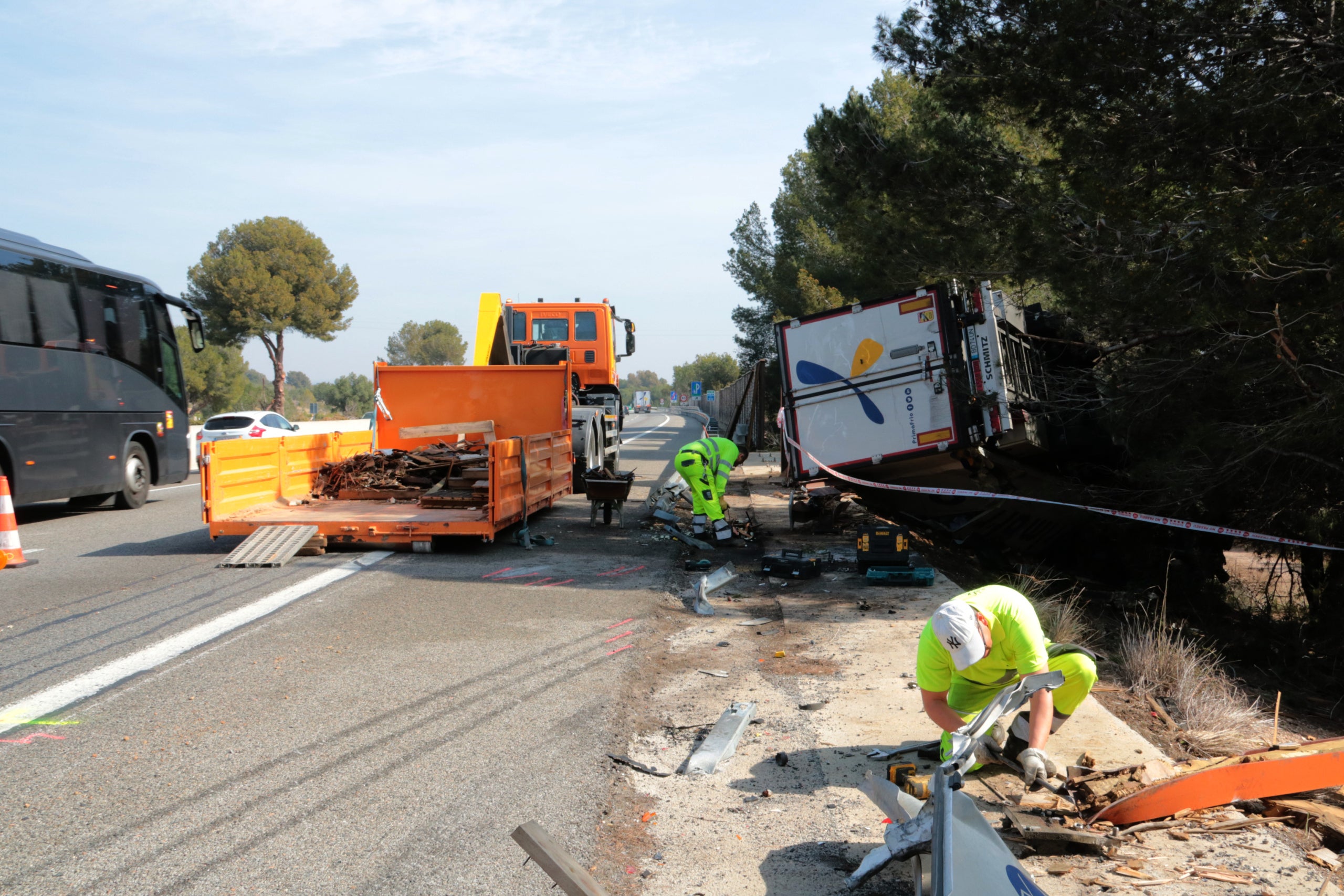 Diversos operaris treballen per retirar el camió accidentat aquesta nit de dissabte a l'AP-7, al Vendrell / ACN