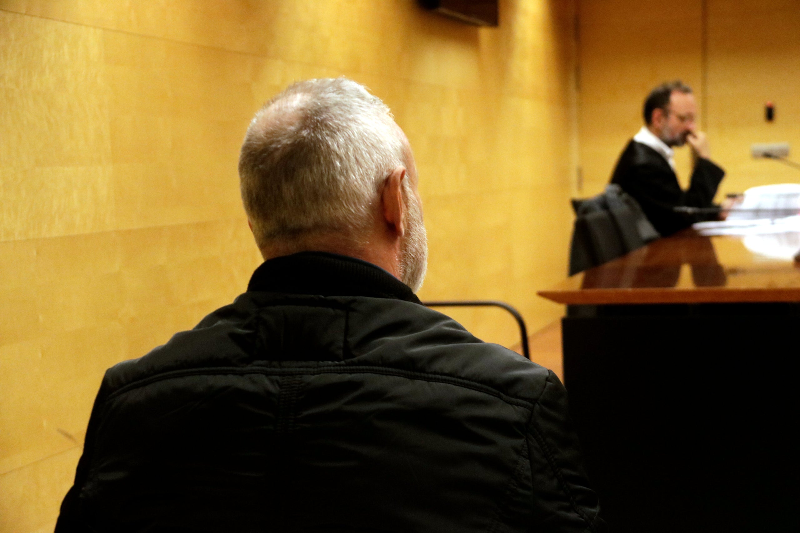 De espaldas, el acusado de prender fuego en casa con los padres dentro, en Sant Antoni de Calonge. Foto del juicio a la Audiencia de Girona / ACN (Marina López)