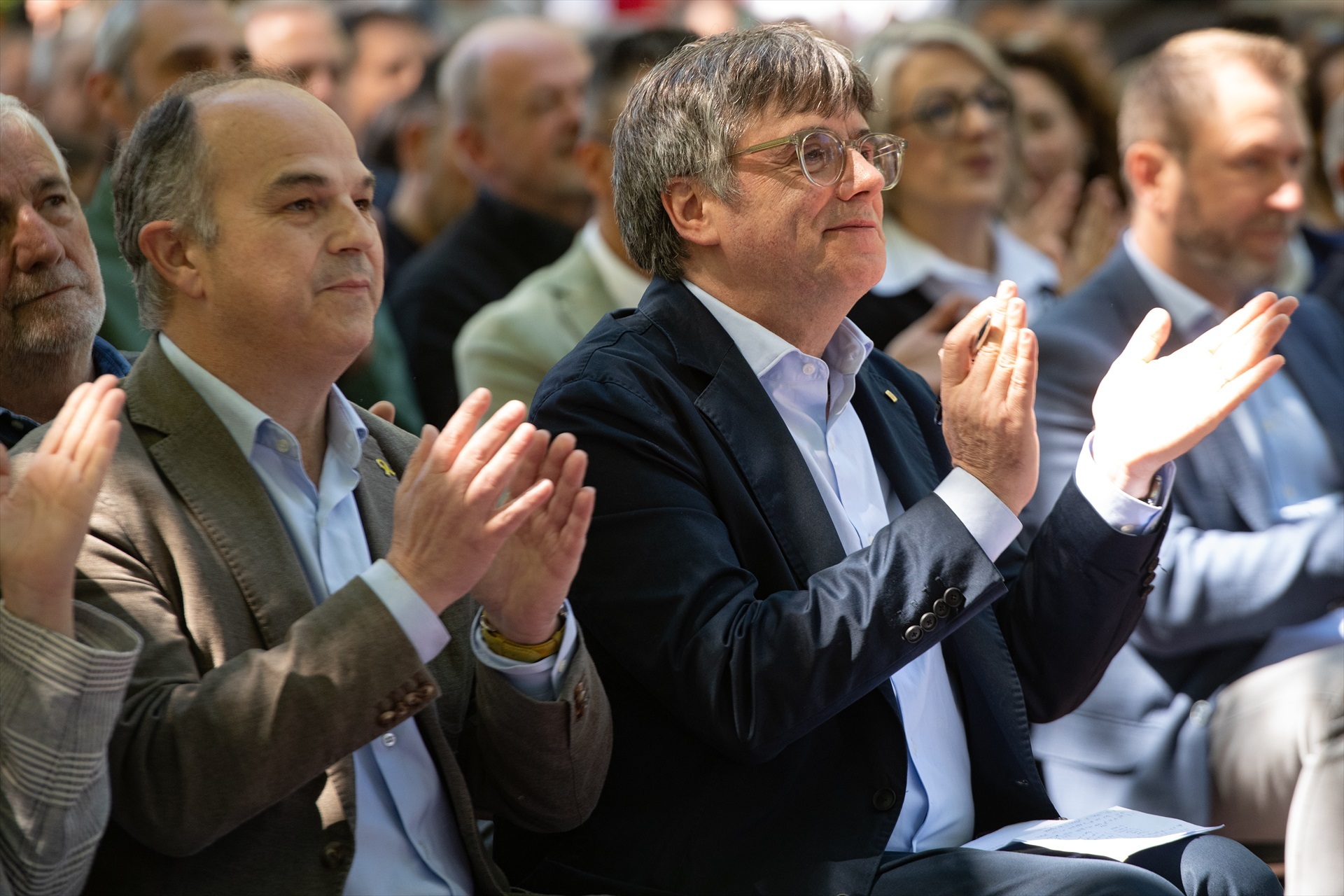 Imatge del president a l'exili, Carles Puigdemont, durant un acte polític de Junts al costat del secretari general del partit, Jordi Turull / Glòria Sánchez - Europa Press