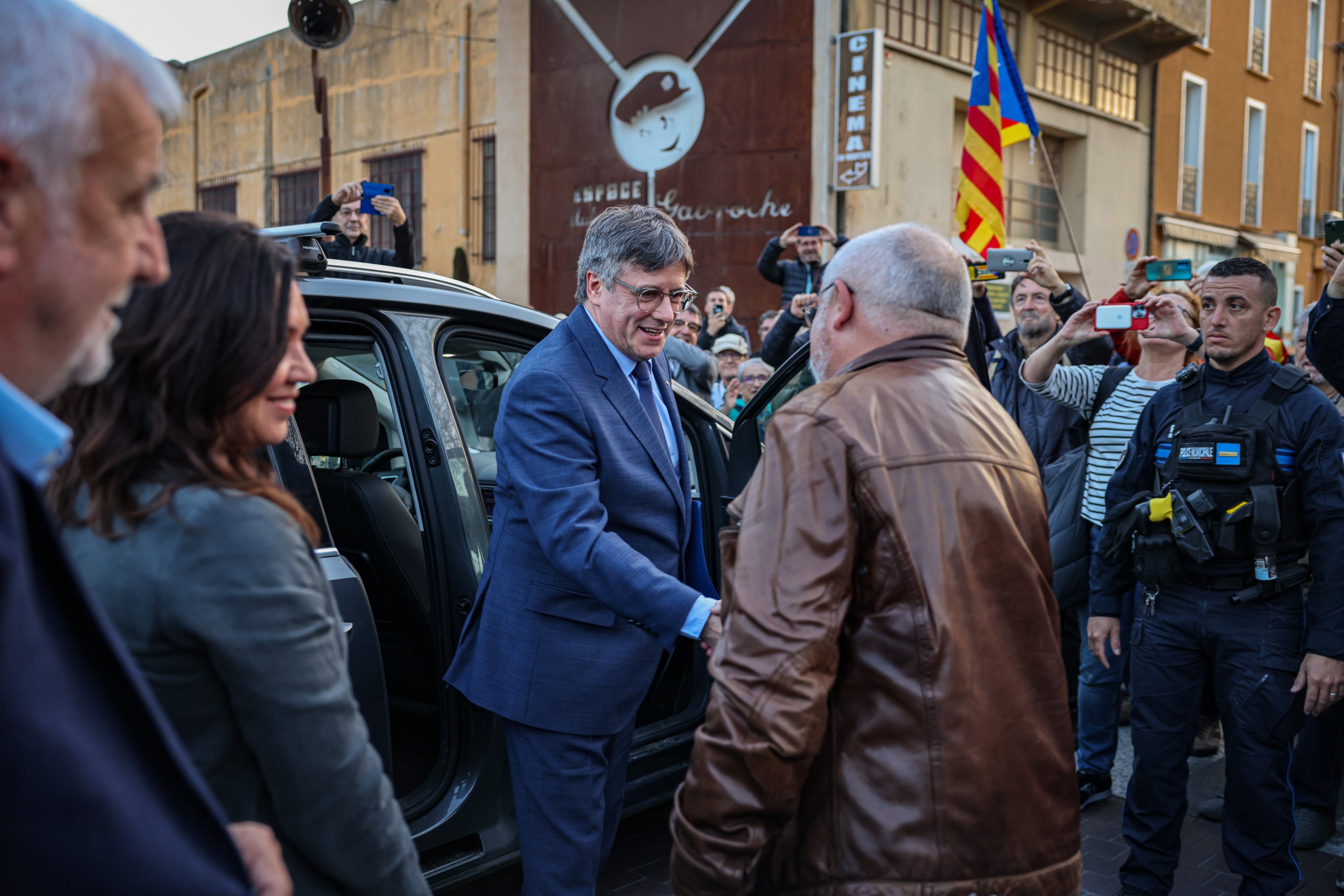 L'expresident Carles Puigdemont arriba a l'Ajuntament d'Elna i saluda l'exconseller Lluís Puig abans de l'acte d'aquest dijous / Jordi Borràs / ACN