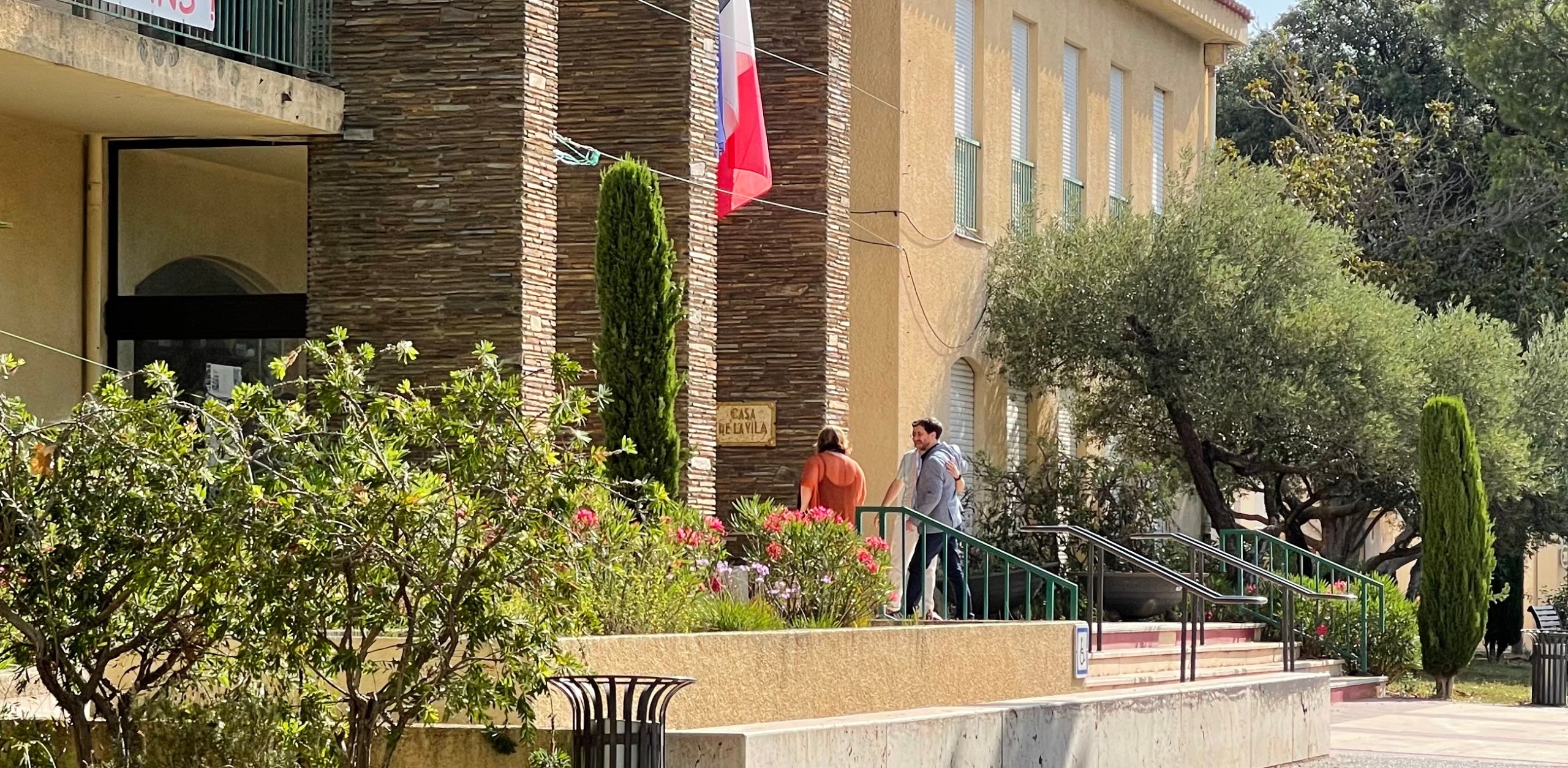 Toni Comín entra a l'ajuntament d'Elna escortat pel responsable de premsa, la seva germana i una