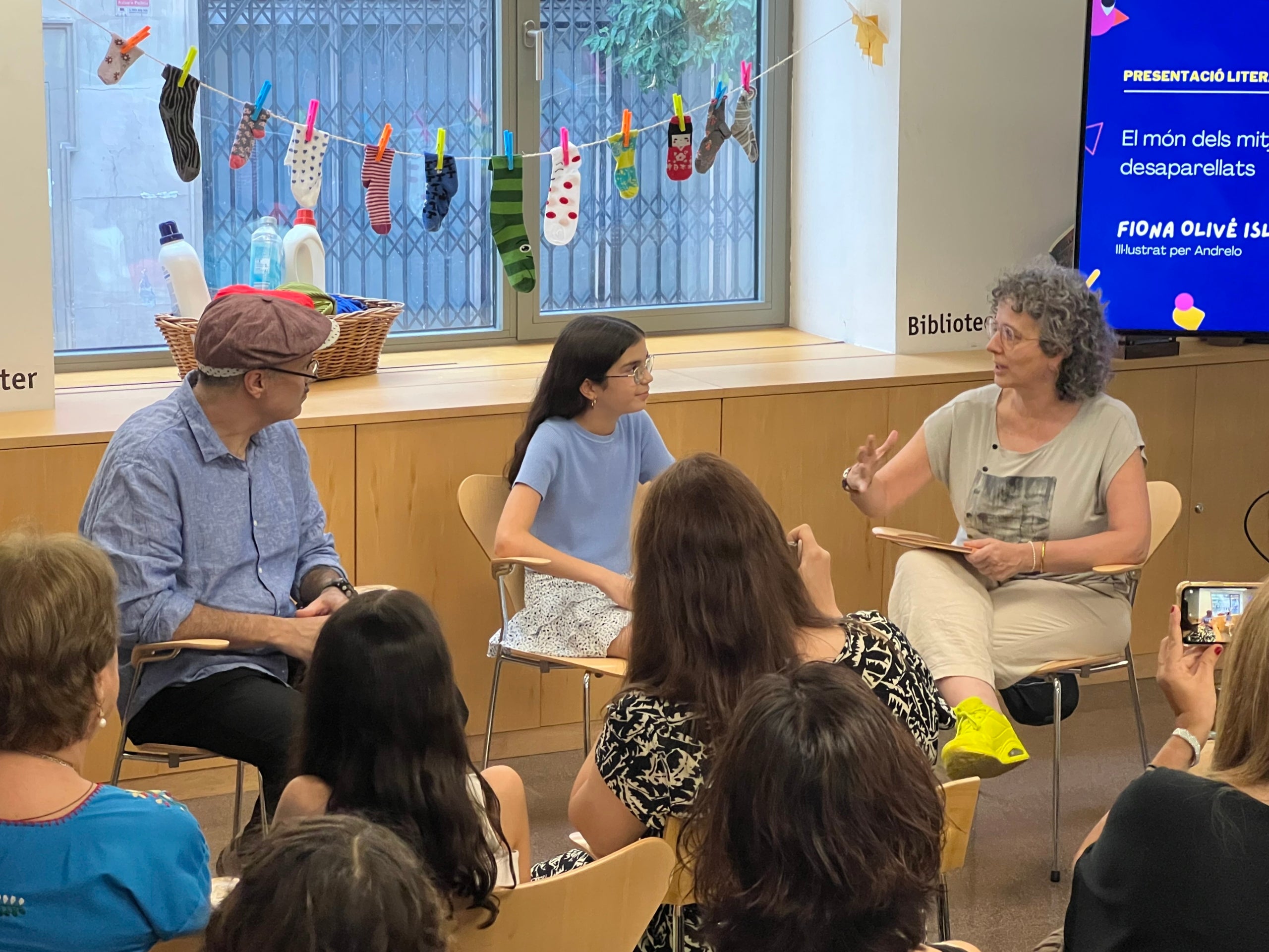 Fiona Olivé, autora del conte 'El món dels mitjons desaparellats', entre els presentadors del llibre: l’actor Cesc Casanovas i la periodista Anna Murgadas / S.C.