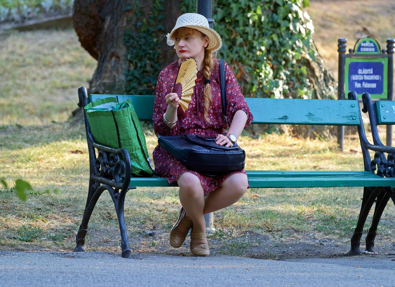Una dona es venta en un parc per combatre la calor / Pixabay