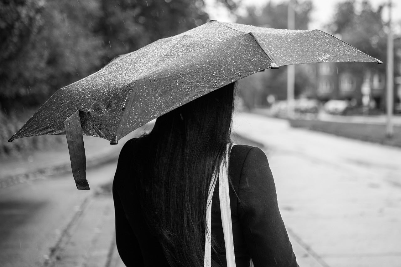 Una dona sota la pluja amb un paraigua / Pixabay