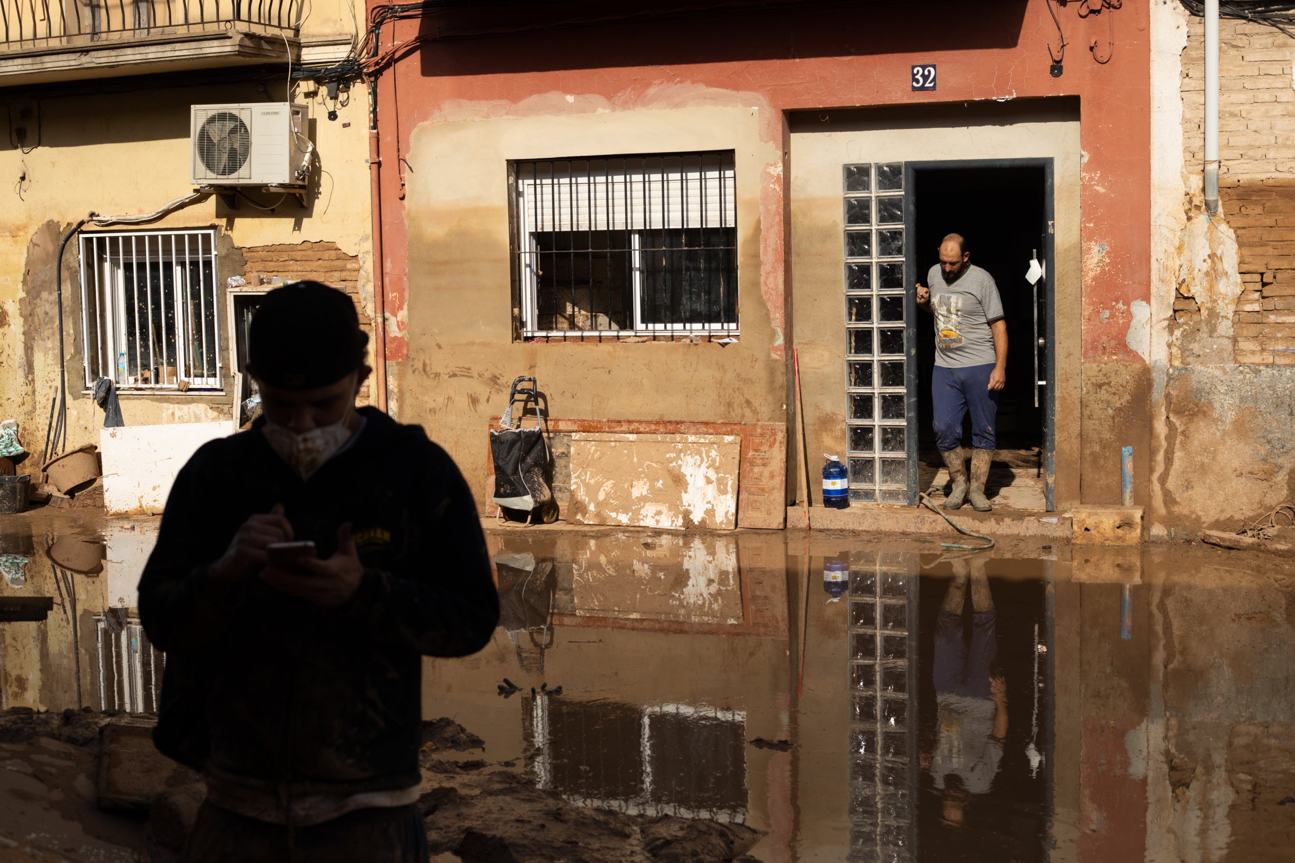 Un vecino del Raval no se atreve a salir de casa por el agua y el barro ante la atención de los voluntarios /Mathias Rodríguez
