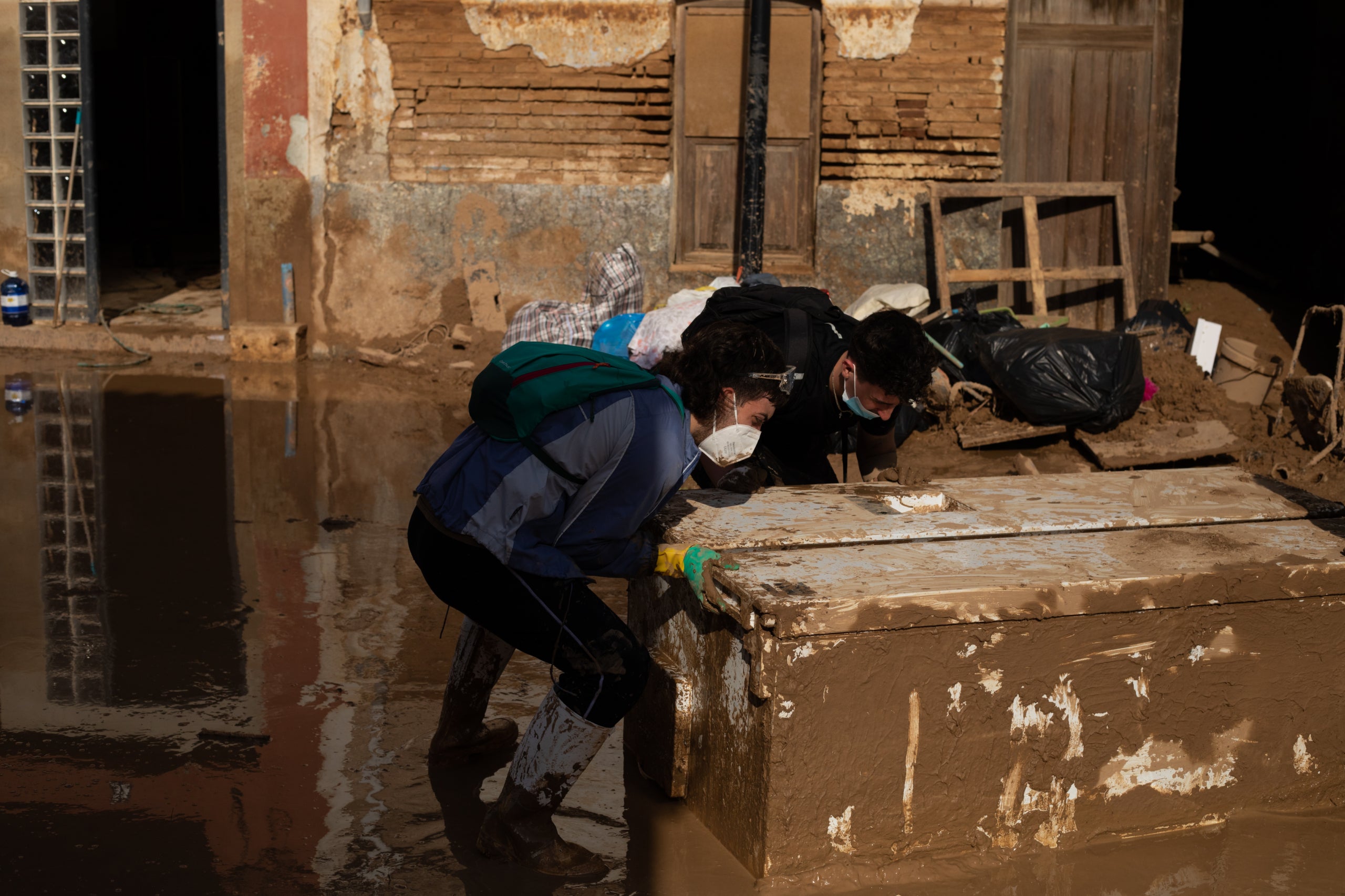 Uns voluntaris arrosseguen un moble al barri del Raval d'Algemesí/Mathias Rodríguez