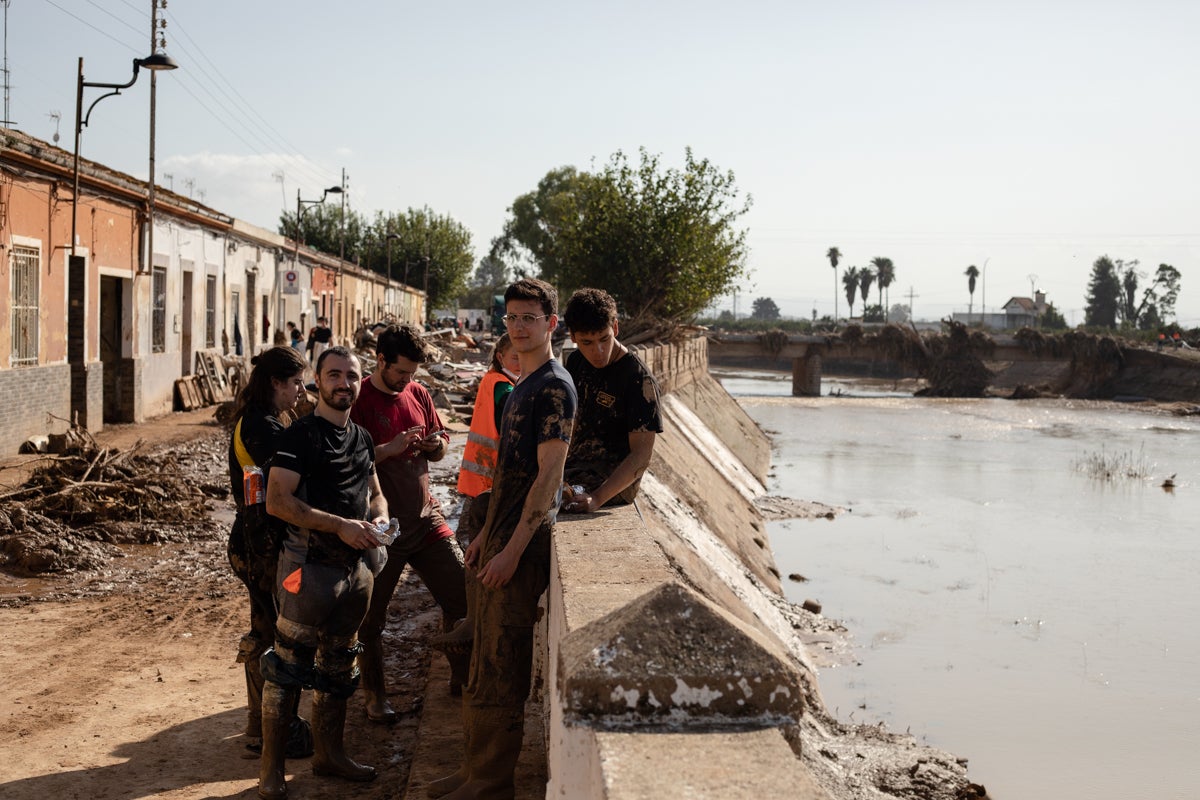 Un grup de voluntaris espera instruccions a tocar del riu Magre a Algemesí/Mathias Rodríguez