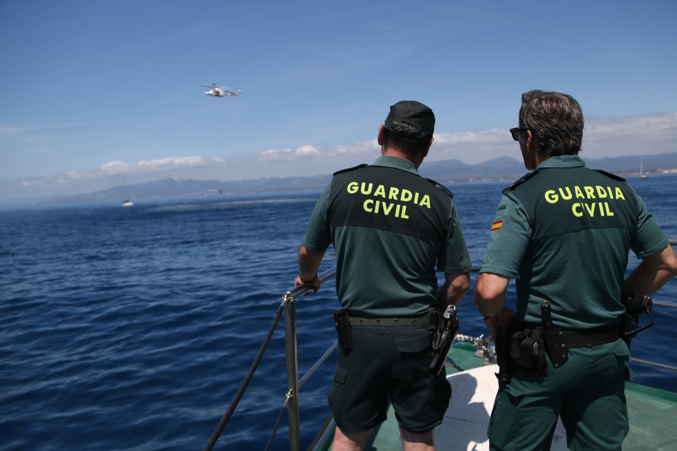 Imagen de archivo de dos agentes de la Guardia Civil y un helicóptero de Salvamento Marítimo / ACN