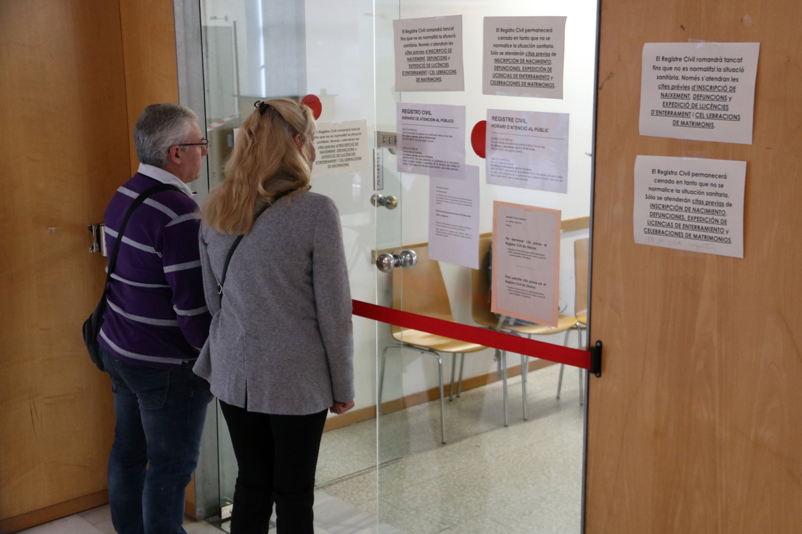 Una pareja frente a la puerta del Registro Civil de los Juzgados de Girona / ACN