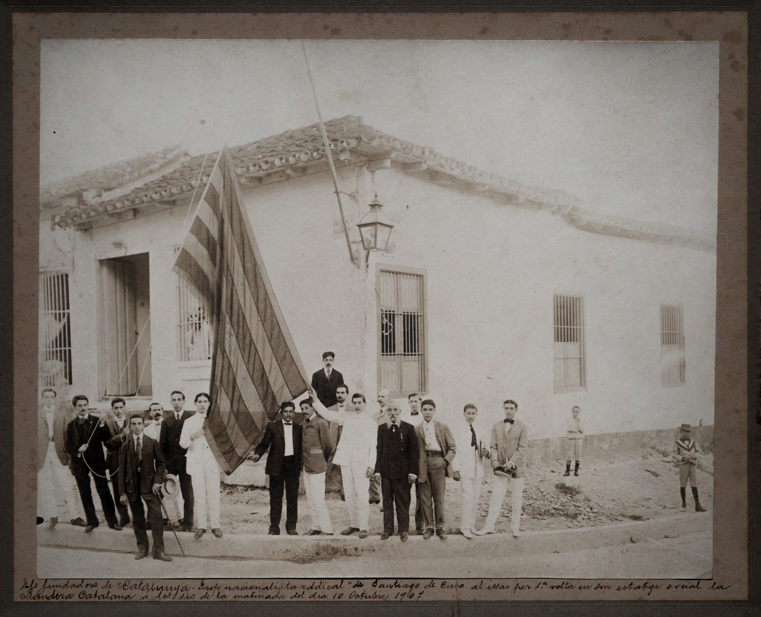 Els socis del Grop Nacionalista Radical de Santiago de Cuba hissen per primera vegada la senyera al seu estatge social (10 d’octubre de 1907) / Fundació Reeixida