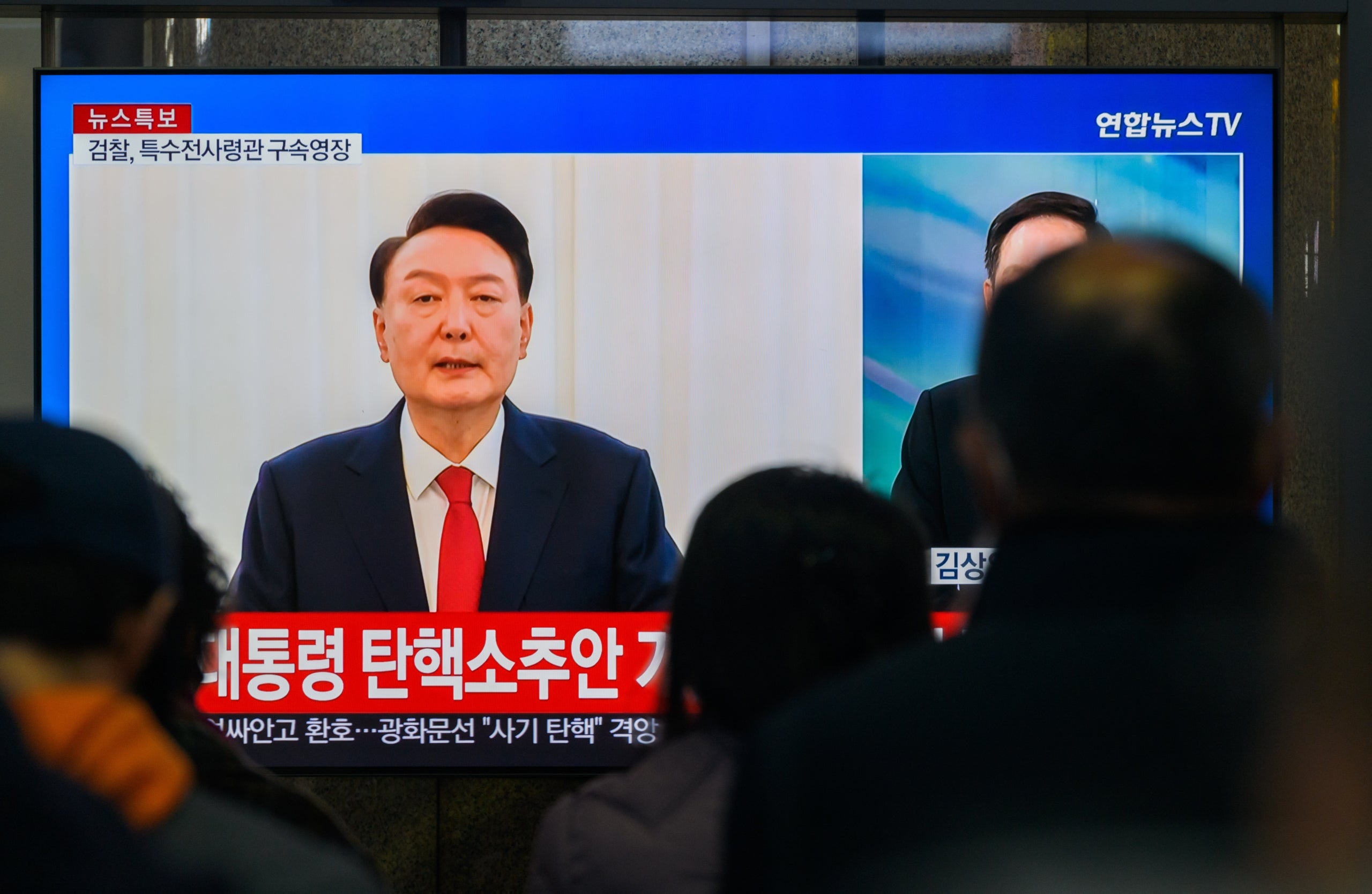 Una emissió de televisió de Yonhap News de 24 hores a l'estació de ferrocarril de Yongsan que mostra el president Yoon Suk Yeol fent un discurs públic des de la seva residència oficial a Seül | Europa Press