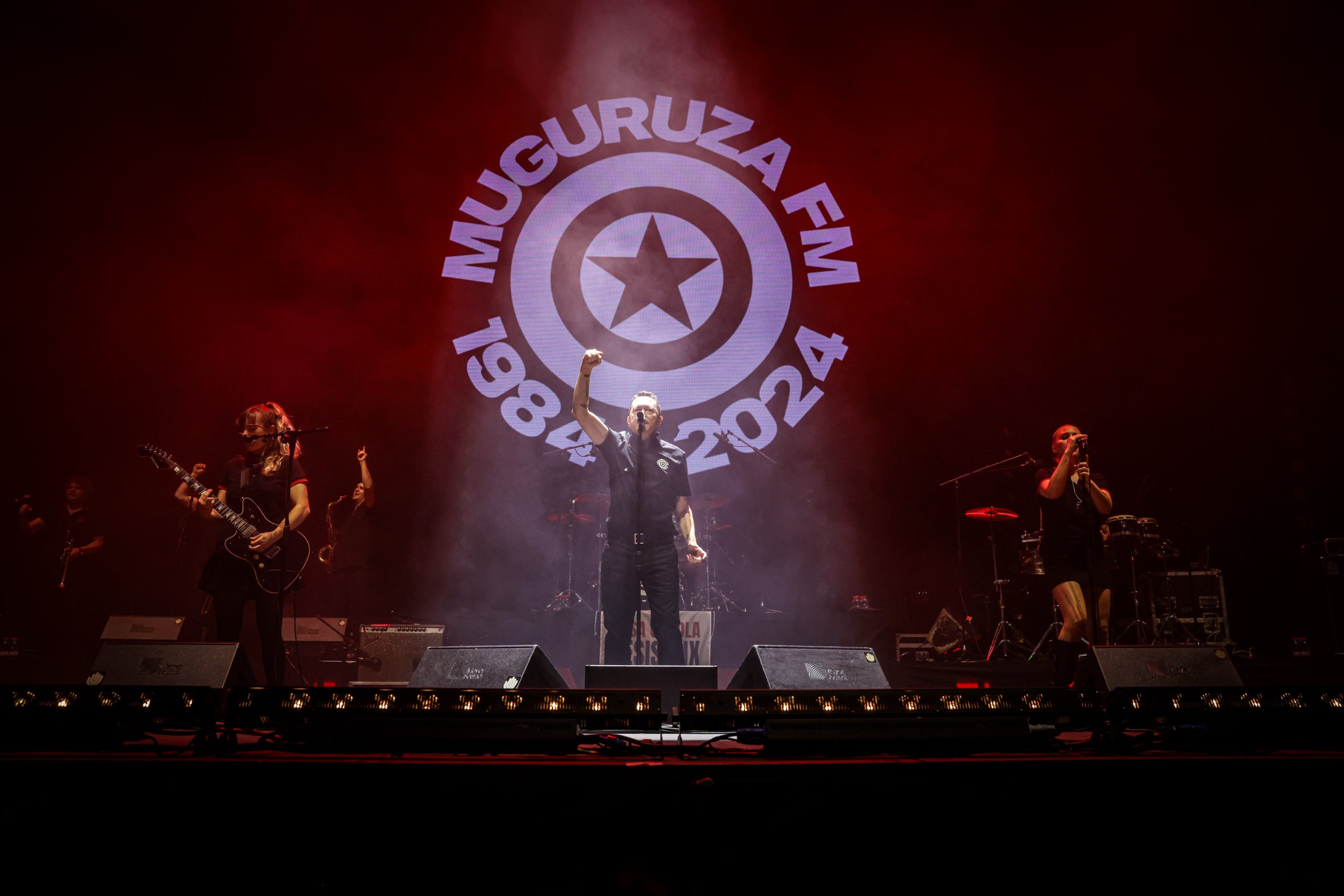 Fermin Muguruza, en un moment del concert al Palau Sant Jordi, davant del logo que deixa constància dels seus 40 anys sobre l'escenari / Jordi Borràs / ACN