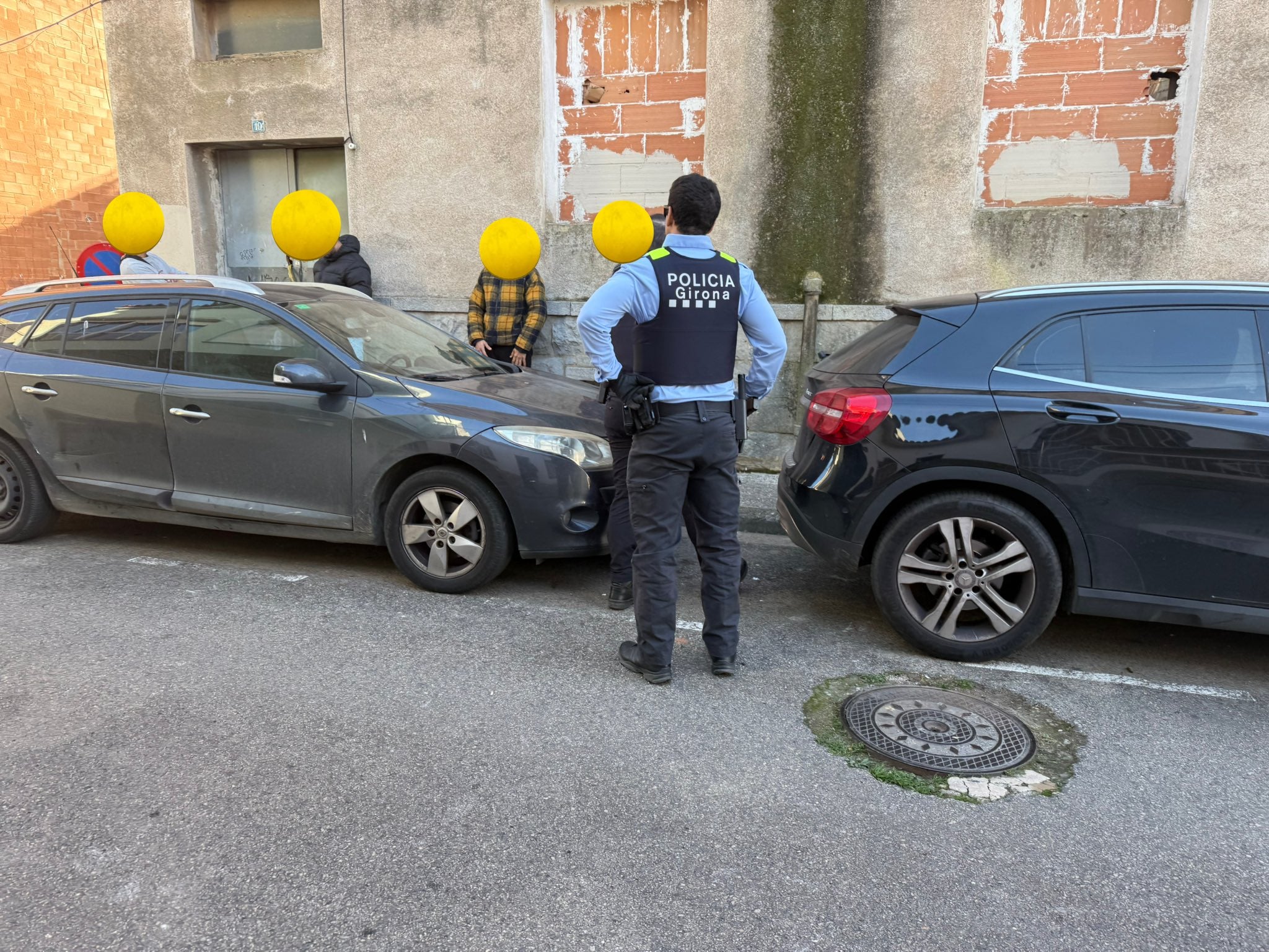 Un agent de la Policia Municipal de Girona amb unes persones amb la cara tapada / Xarxa X Jordi Riera