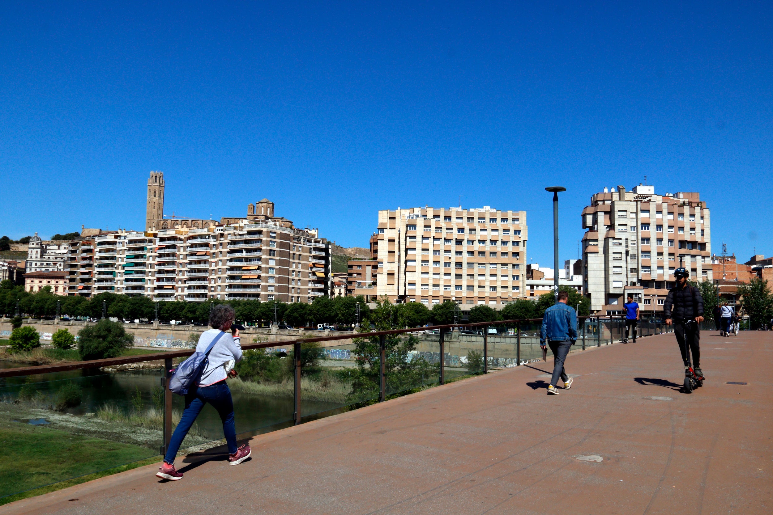 Vianants i usuaris de patinets a la passarel·la dels Camps Elisis de Lleida. | Roger Segura (ACN)
