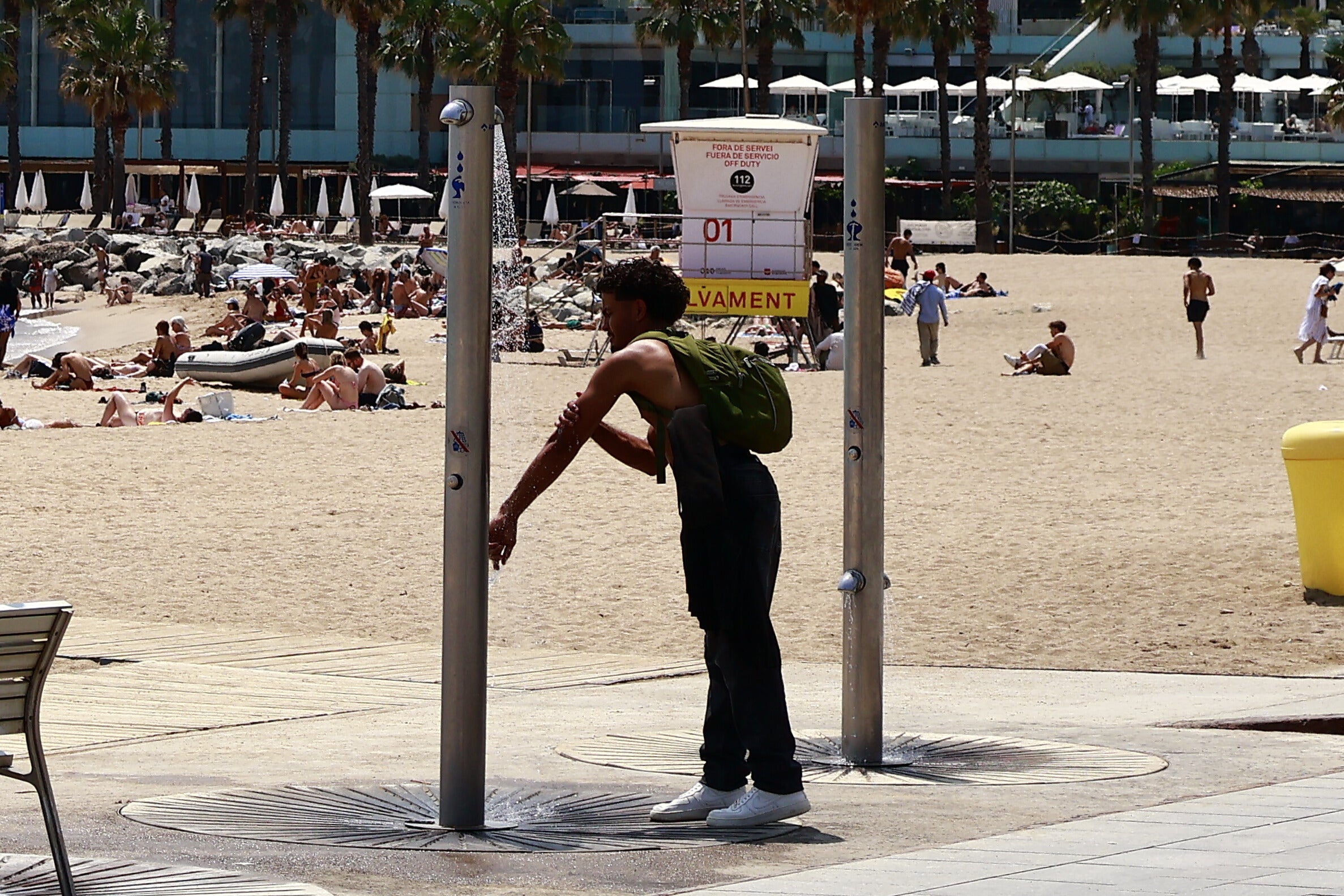 Calor. Un noi aprofita per refrescar-se a les dutxes de la platja de la Barceloneta degut a les altes temperatures. / Marta Cardenal 