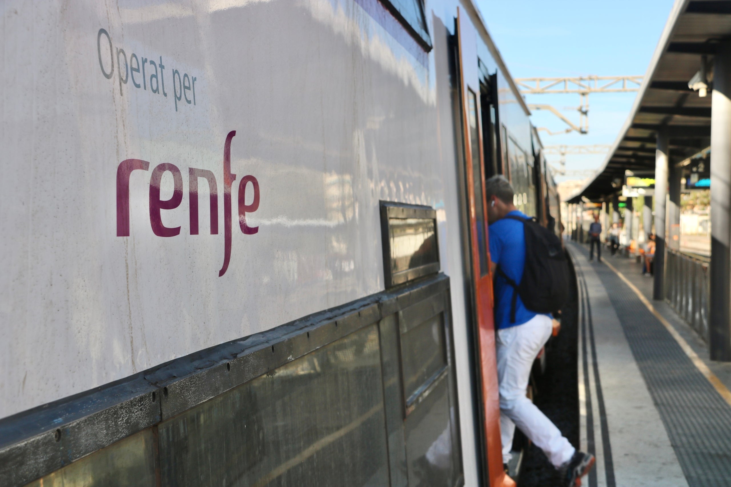 Un  usuari de Rodalies puja al tren a l'estació de Gavà, i es pot observar la distància que hi ha amb l'andana / ACN