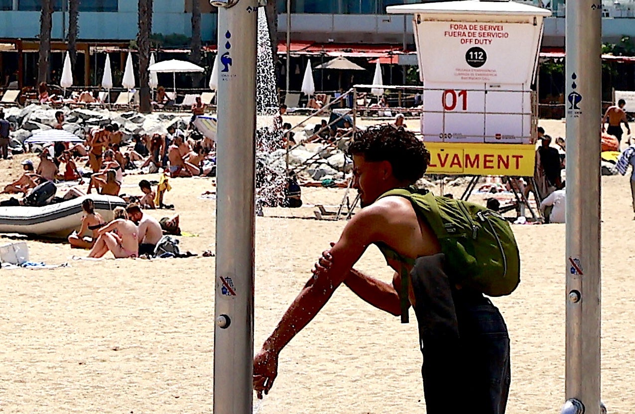 Calor. Un noi es refresca en una dutxa d'una platja de Barcelona per combatre la calor dels primers dies de juny. / Marta Cardenal