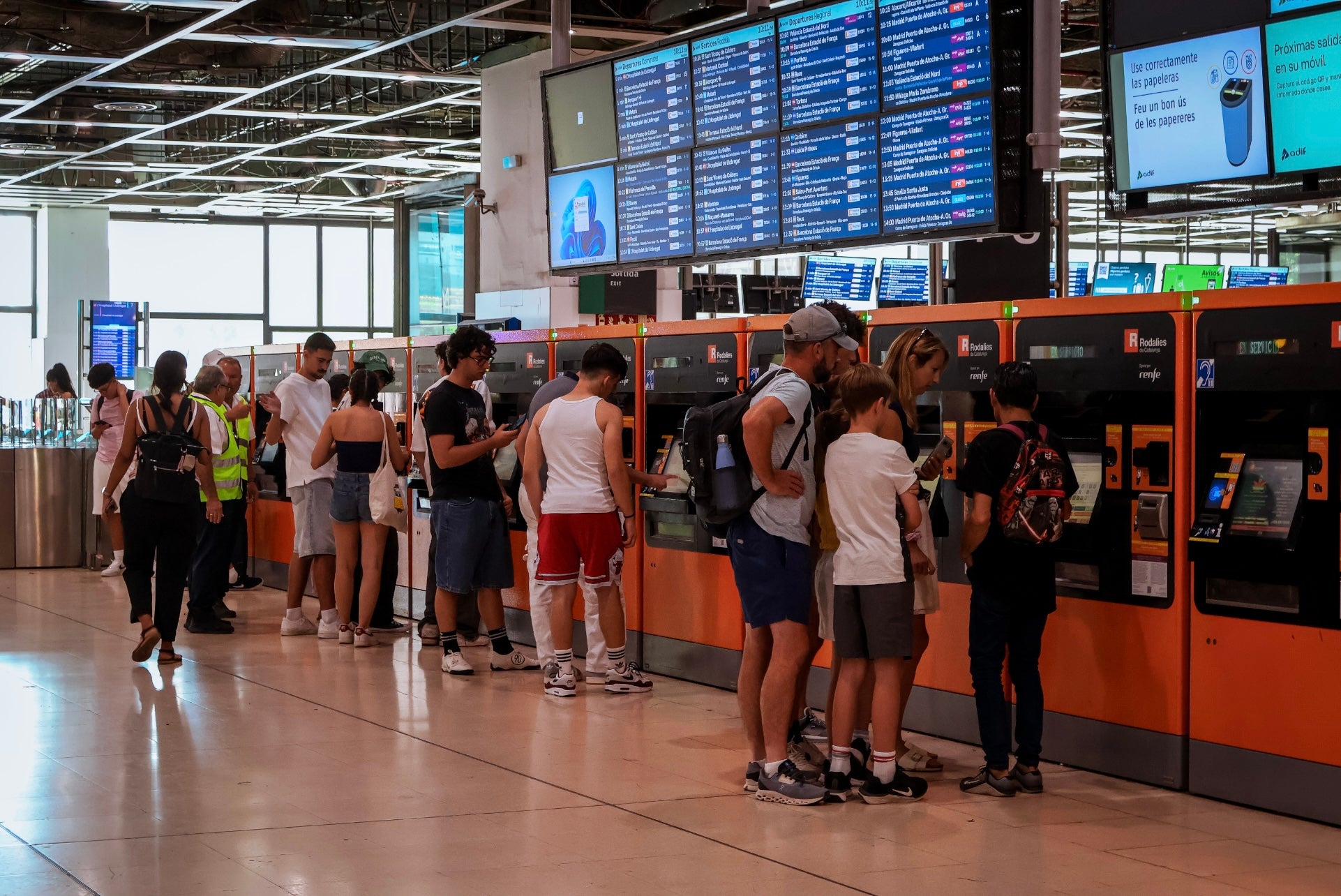 Usuarios de Rodalies consultan los horarios y billetes en la estación de Sants, en Barcelona. / Marta Cardenal