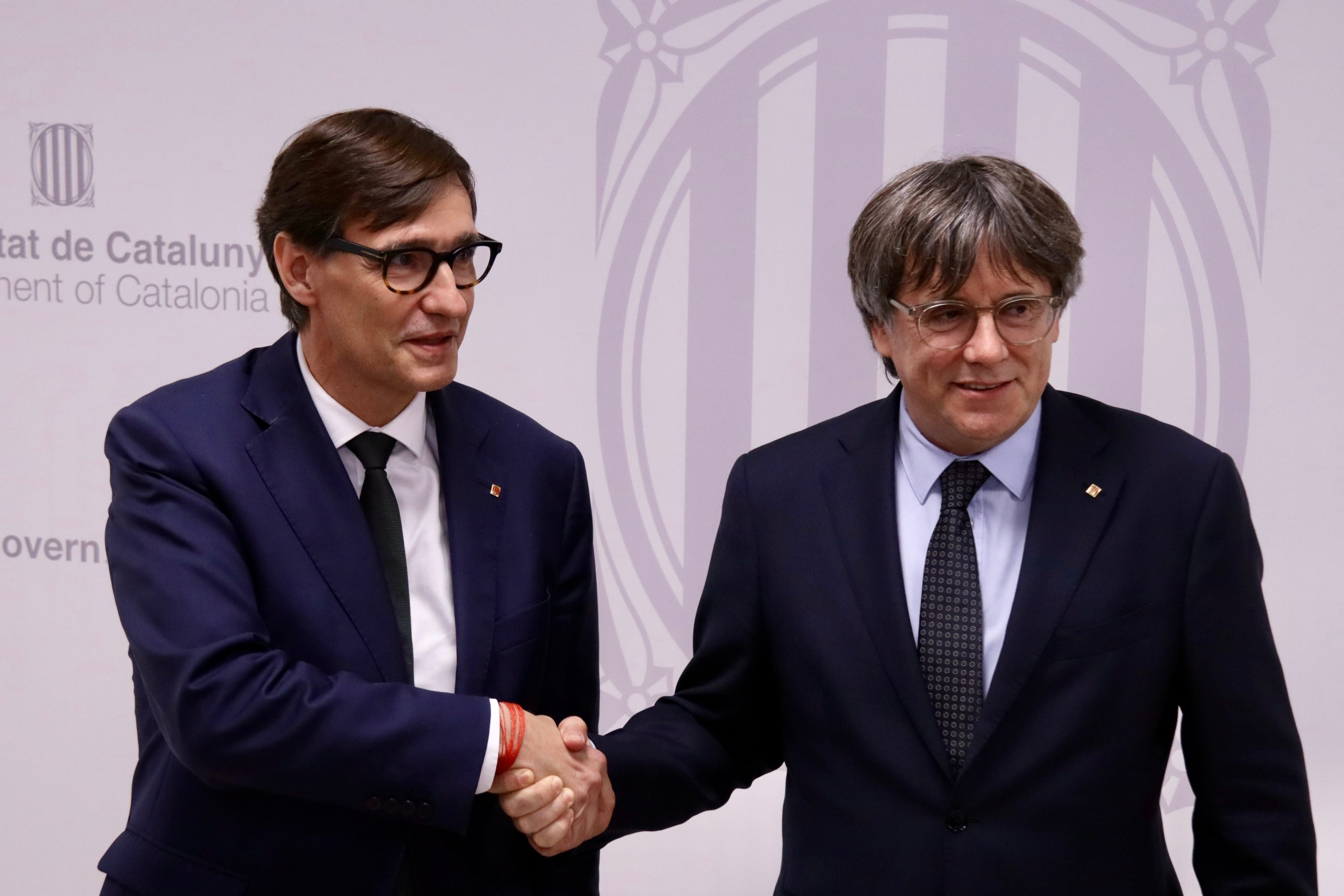 El president de la Generalitat, Salvador Illa, encaixa la mà amb el president de Junts i expresident de la Generalitat, Carles Puigdemont / ACN