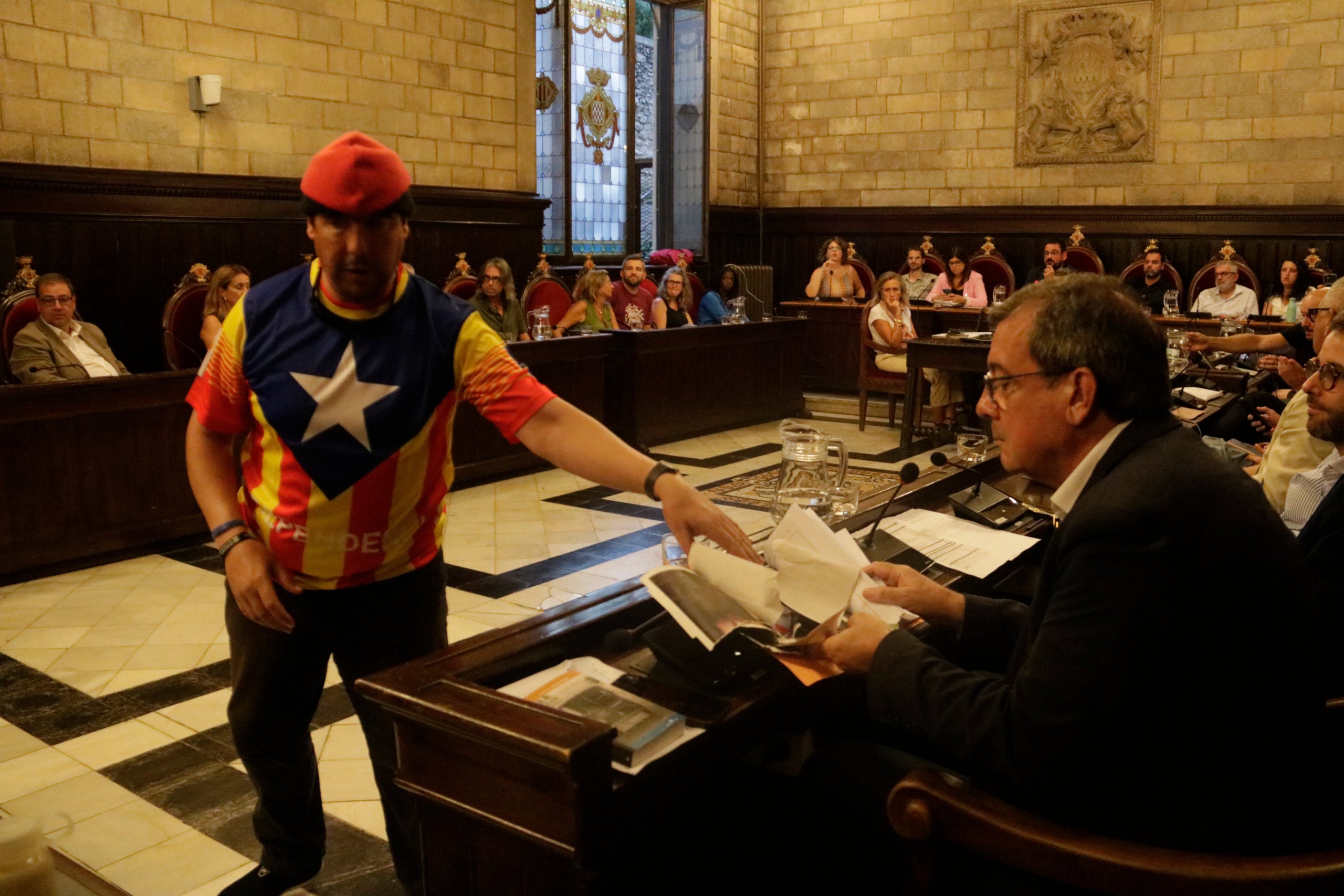 Un manifestant antimonàrquic entrega la foto estripada de Felip VI a un regidor de Vox / ACN