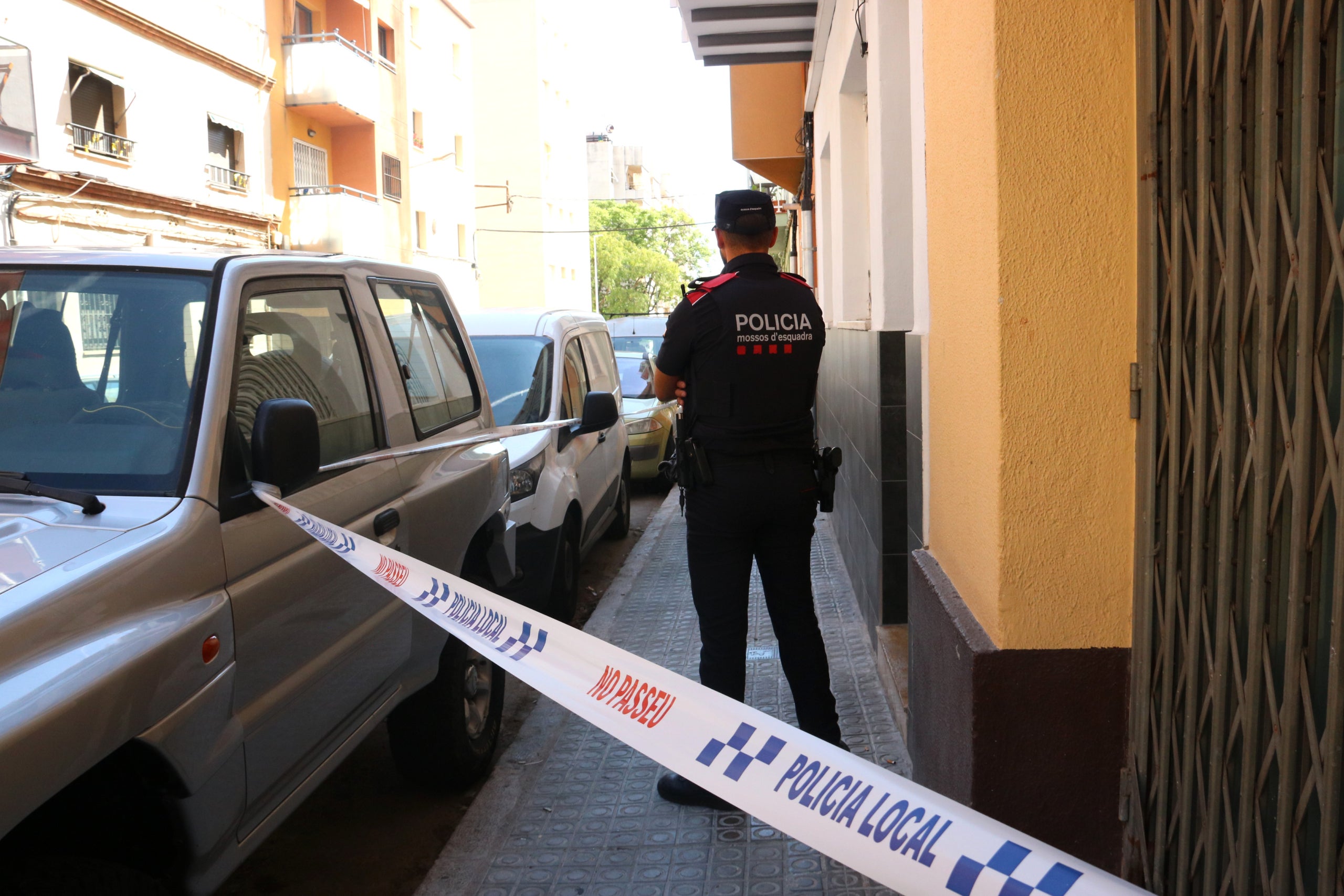 Un mossos d'esquadra en la puerta del edificio donde viviría el detenido. / ACN