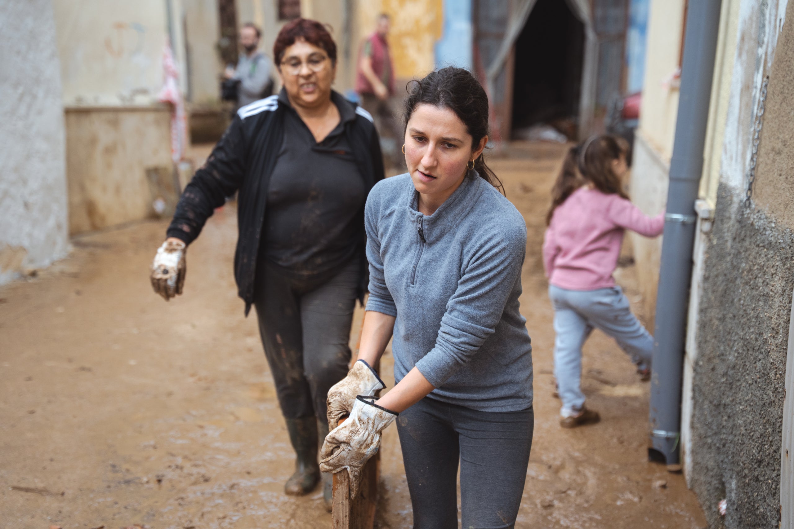 Vecinos retiran basura y barro de las casas y calles de Godall por las inundaciones en las Tierras del Ebro / Marc Font (ACN)
