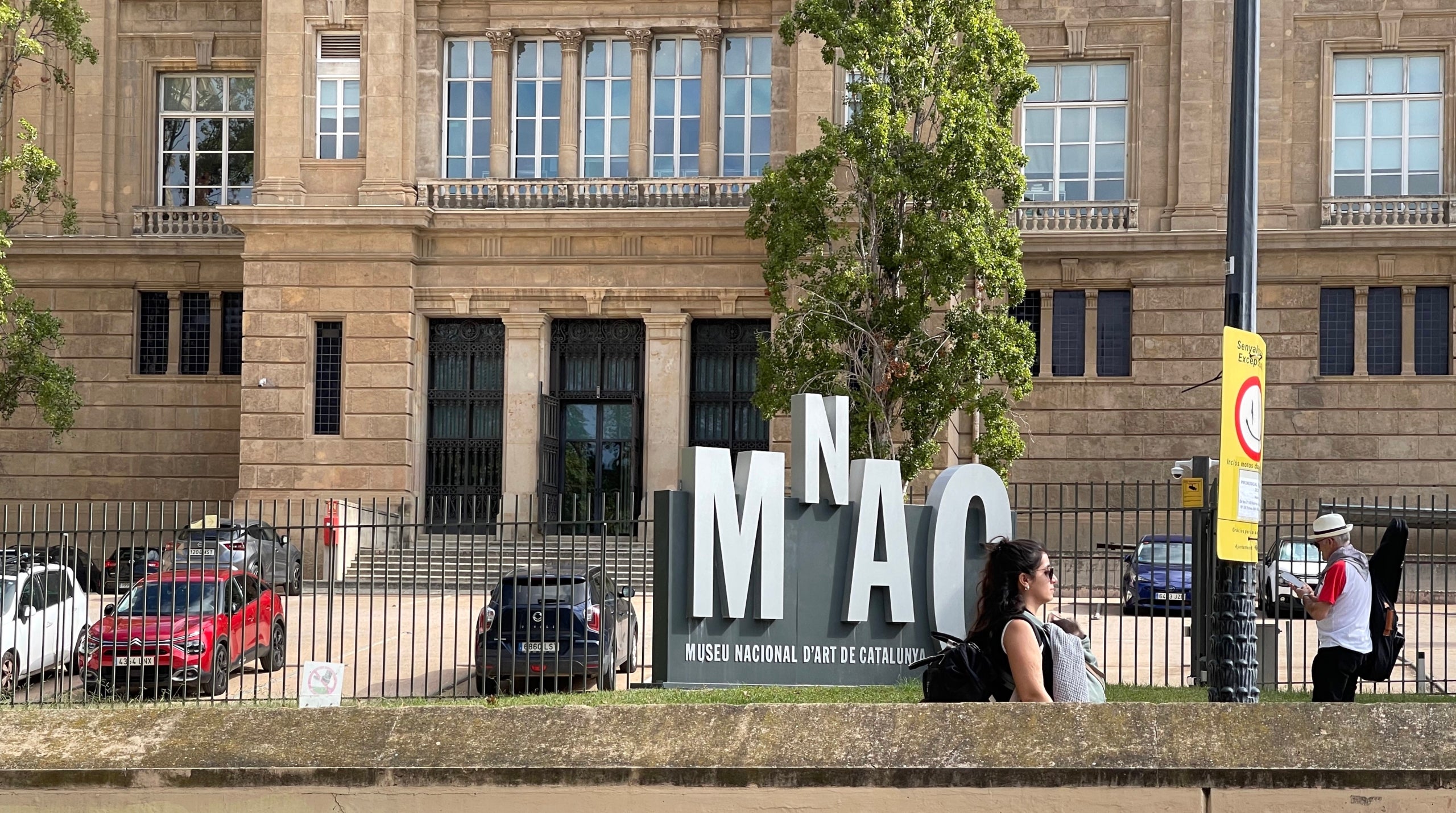 Una señora con un niño caminan frente al MNAC donde se encuentran las pinturas de Sixena/Quico Sallés