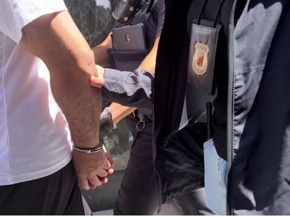 Una imatge d'una detenció amb un policia identificat com a Mosso amb una placa/Mossos