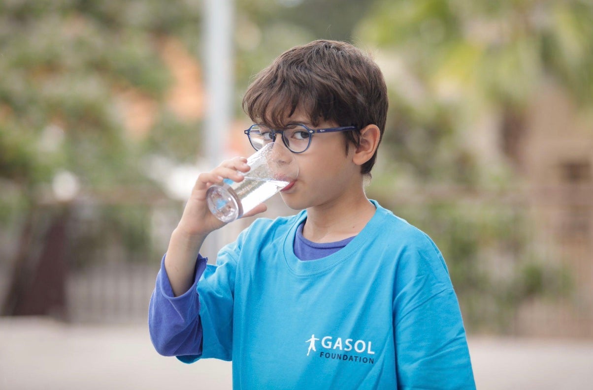 Un niño bebiendo agua con la camiseta de la Gasol Foundation / Cedida